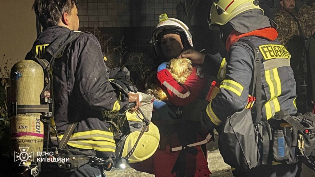 Рятувальниця несе собачку, врятованого з будинку після російського обстрілу