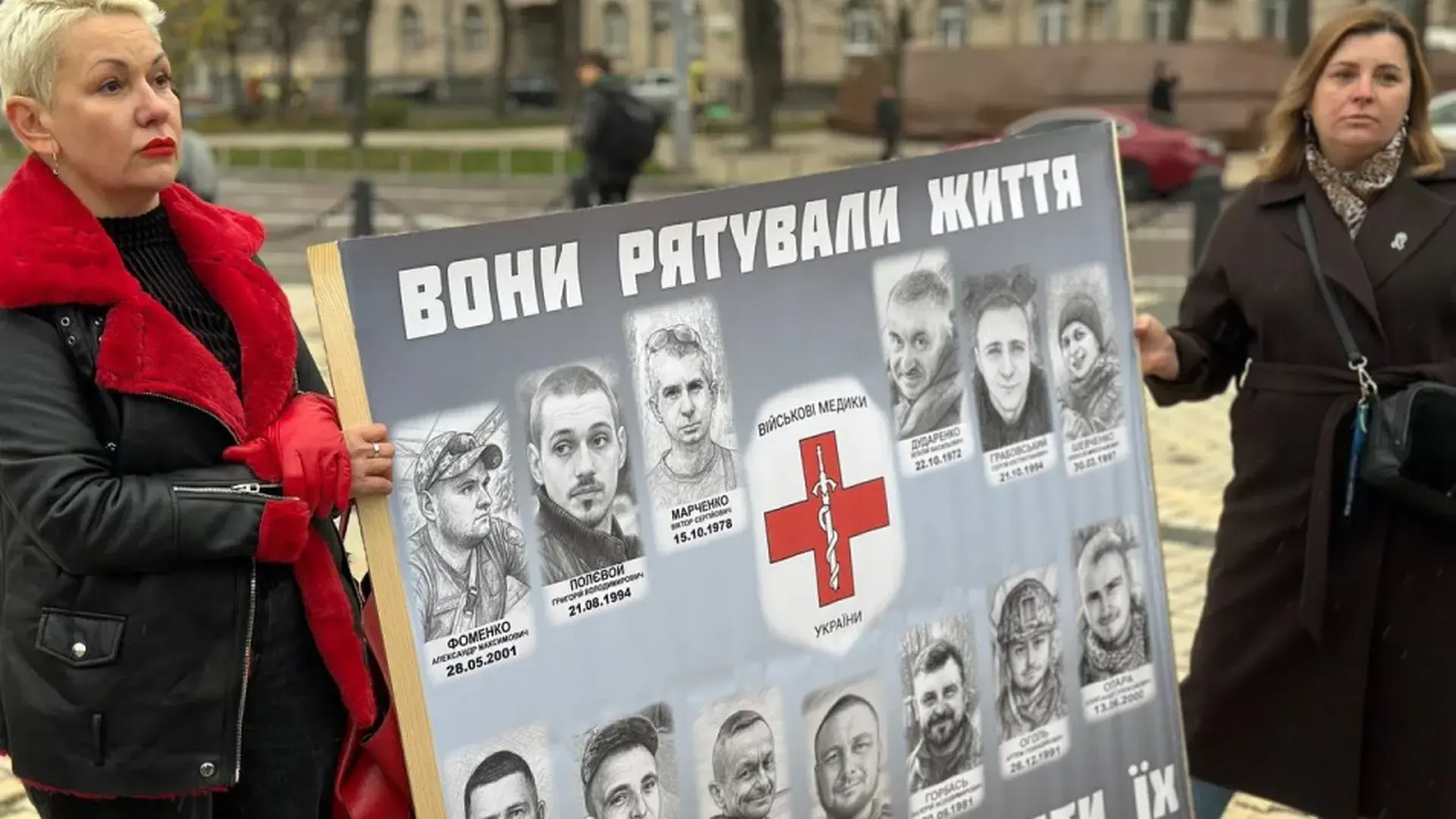Дві жінки тримають плакат