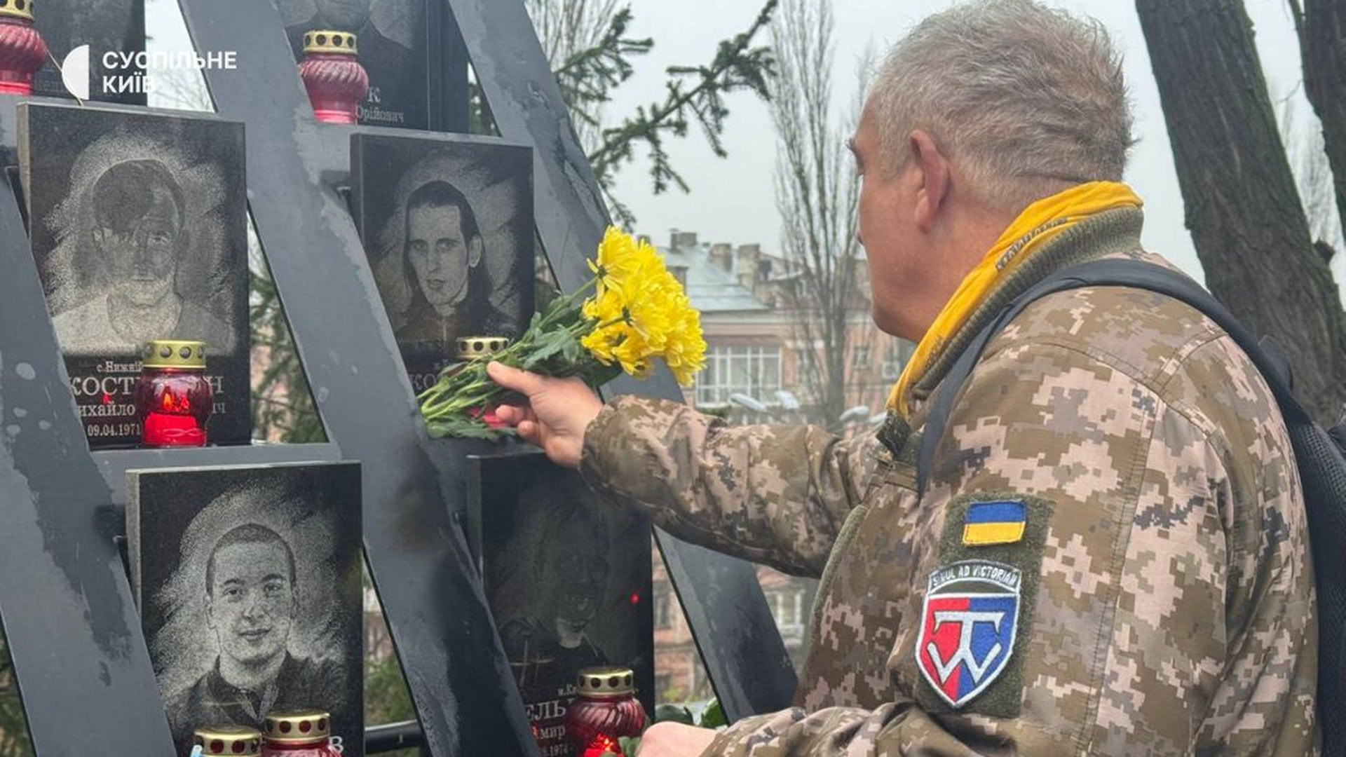 Чоловік покладає квіти до меморіалу Героям Небесної сотні
