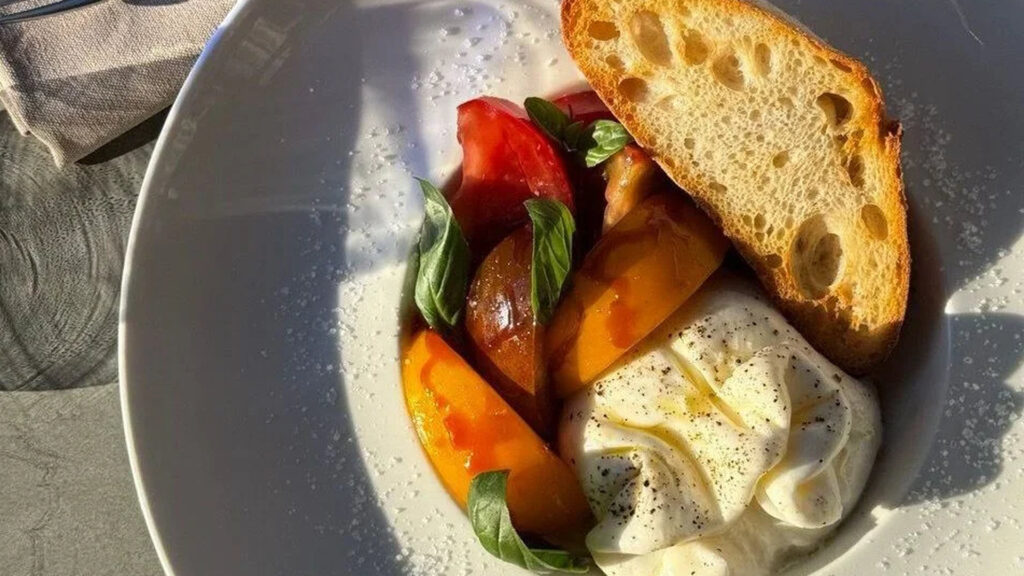 Найуспішніші італійські ресторани України: два з них у Києві Тарілка з їжею з ресторану: помідори, підсмажений хліб і сир з листочками базиліку