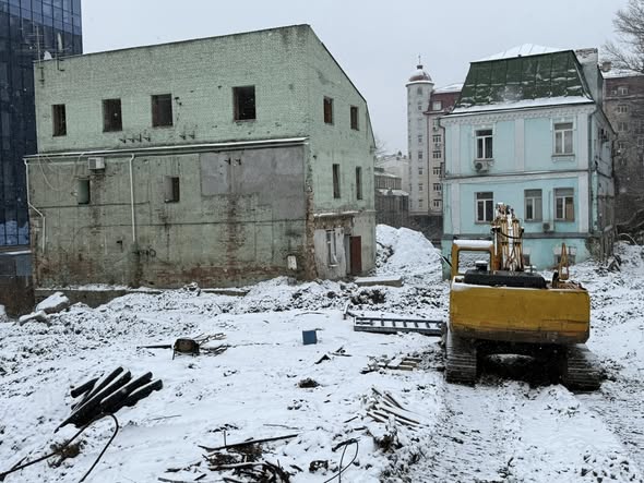 Екскаватор біля двох історичних будинків