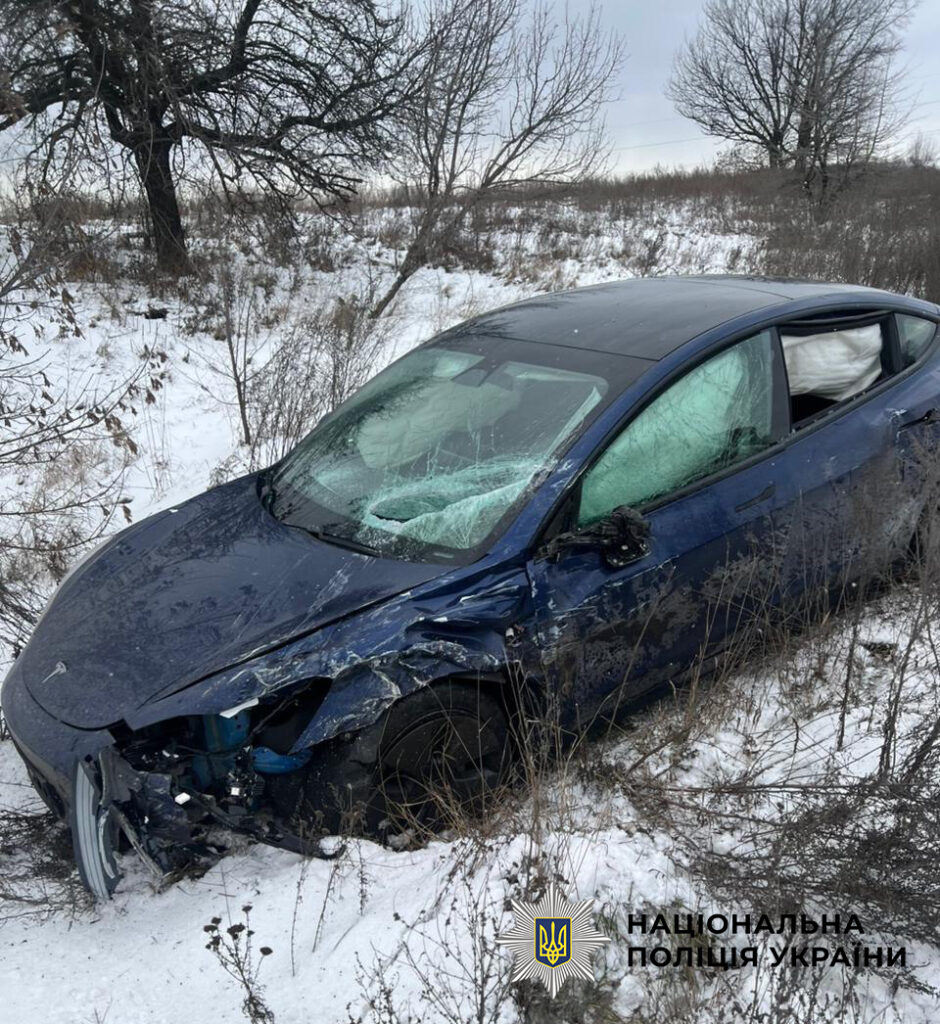 Автомобіль Tesla Model 3 синього кольору з'їхавший з дороги, фото зблизька