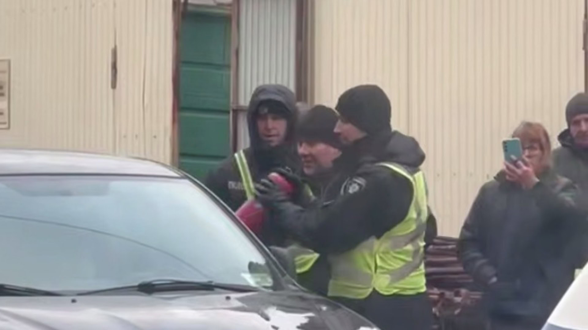 Поліцейські розбивають вікно автівки вогнегасником