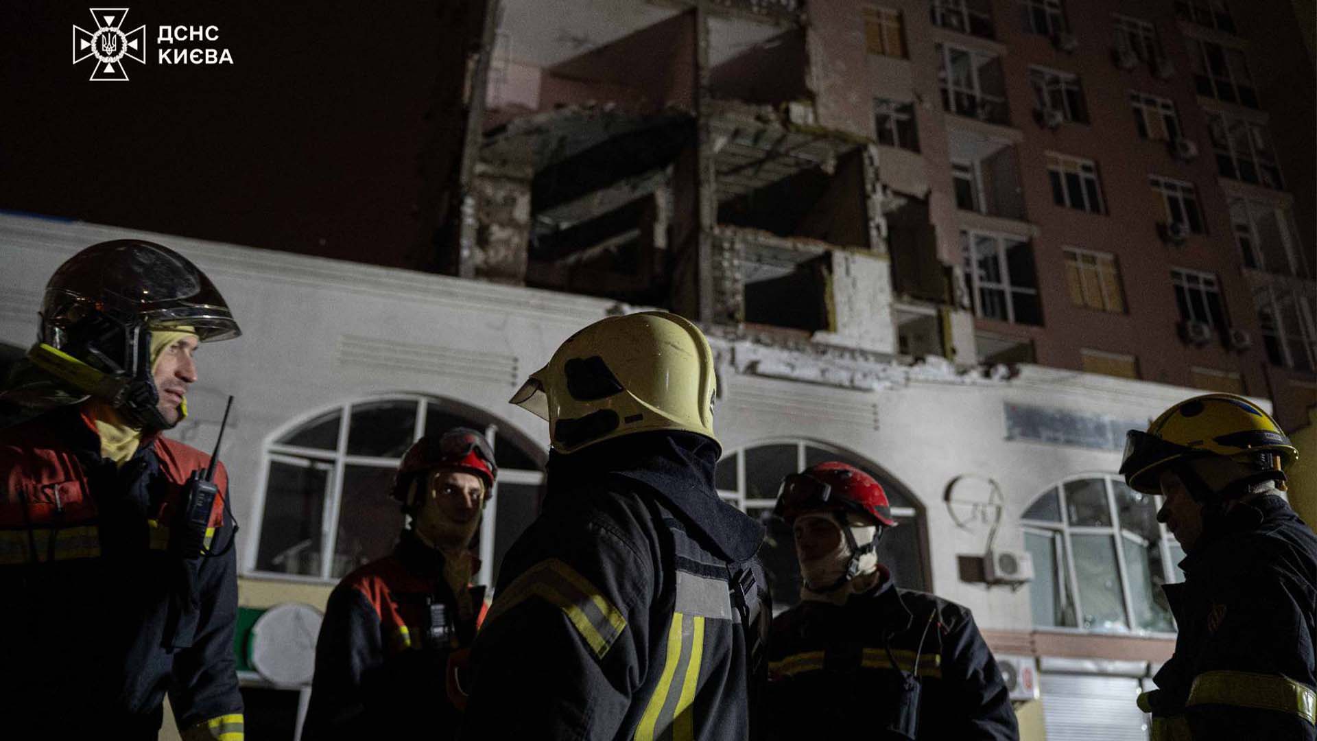 Рятувальники перед будинком, сегмент якого зруйнований обстрілом