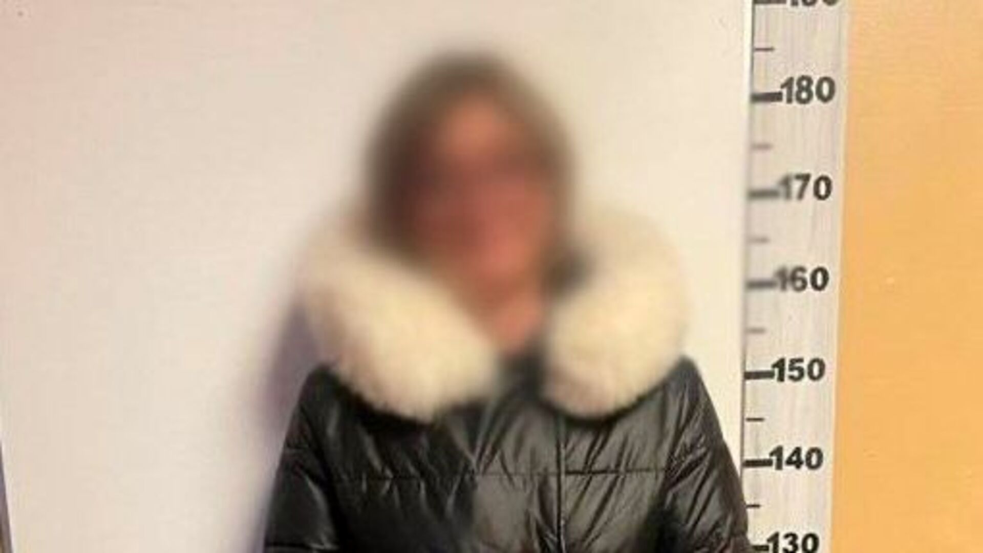 Заблюрене фото затриманої жінки в поліцейському відділку