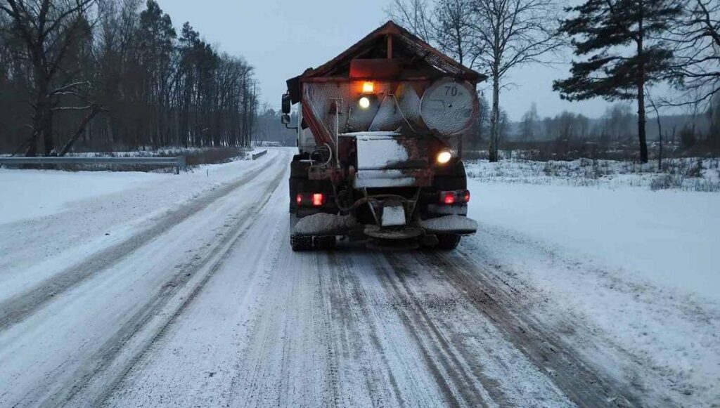 Вантажівка з сумішшю проти ожеледиці їде по дорозі