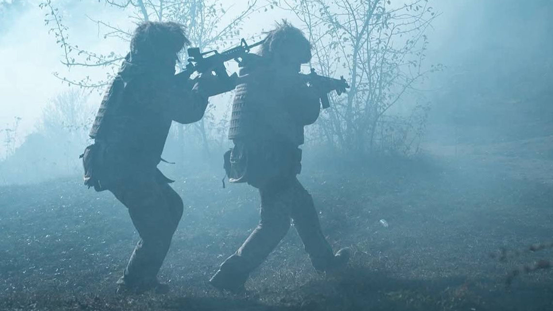 Два бійці ЗСУ ідуть по лісу в зимовий час зі зброєю