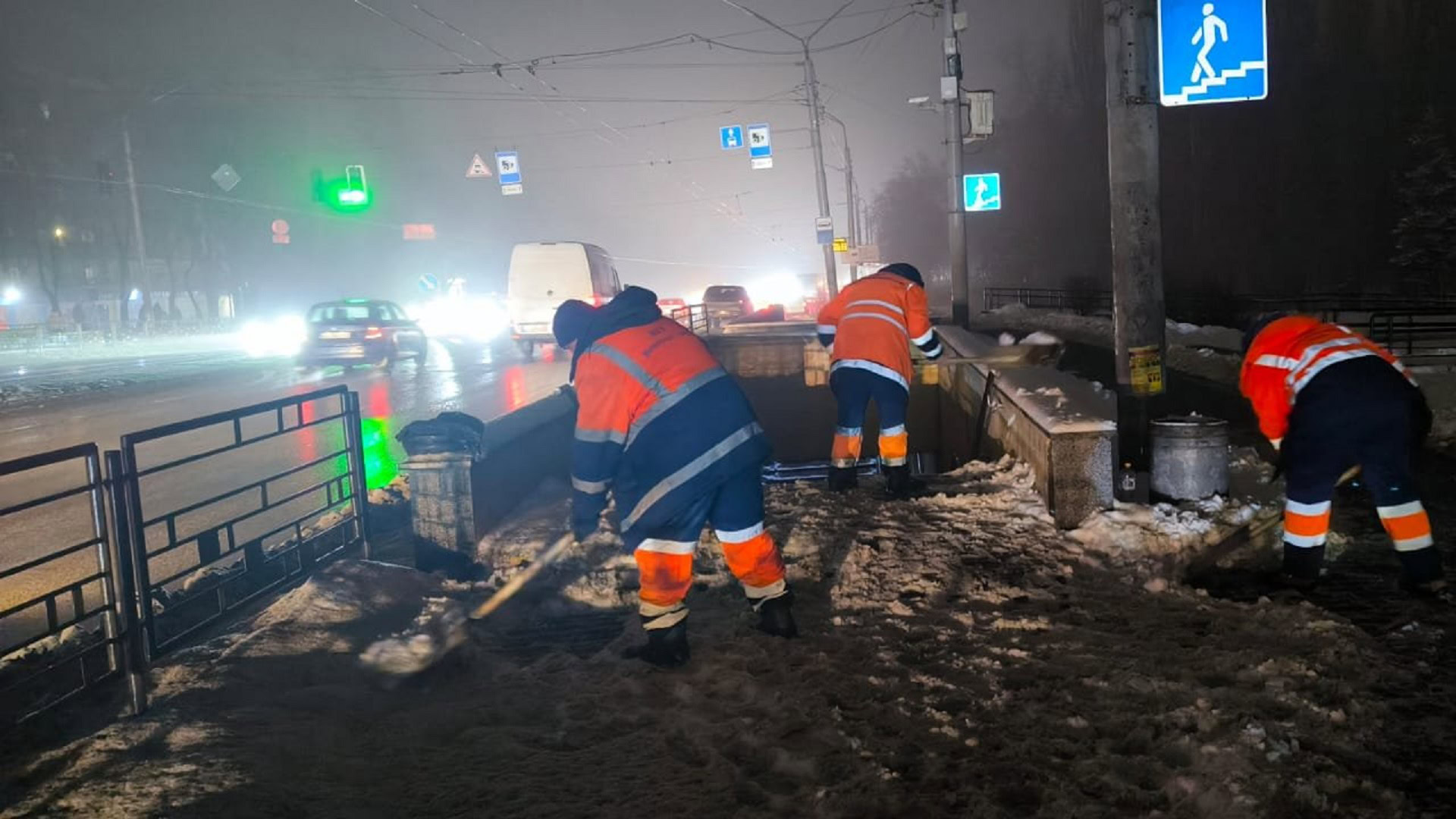 Працівники комунальної служби очищають від снігу територію біля підземного переходу