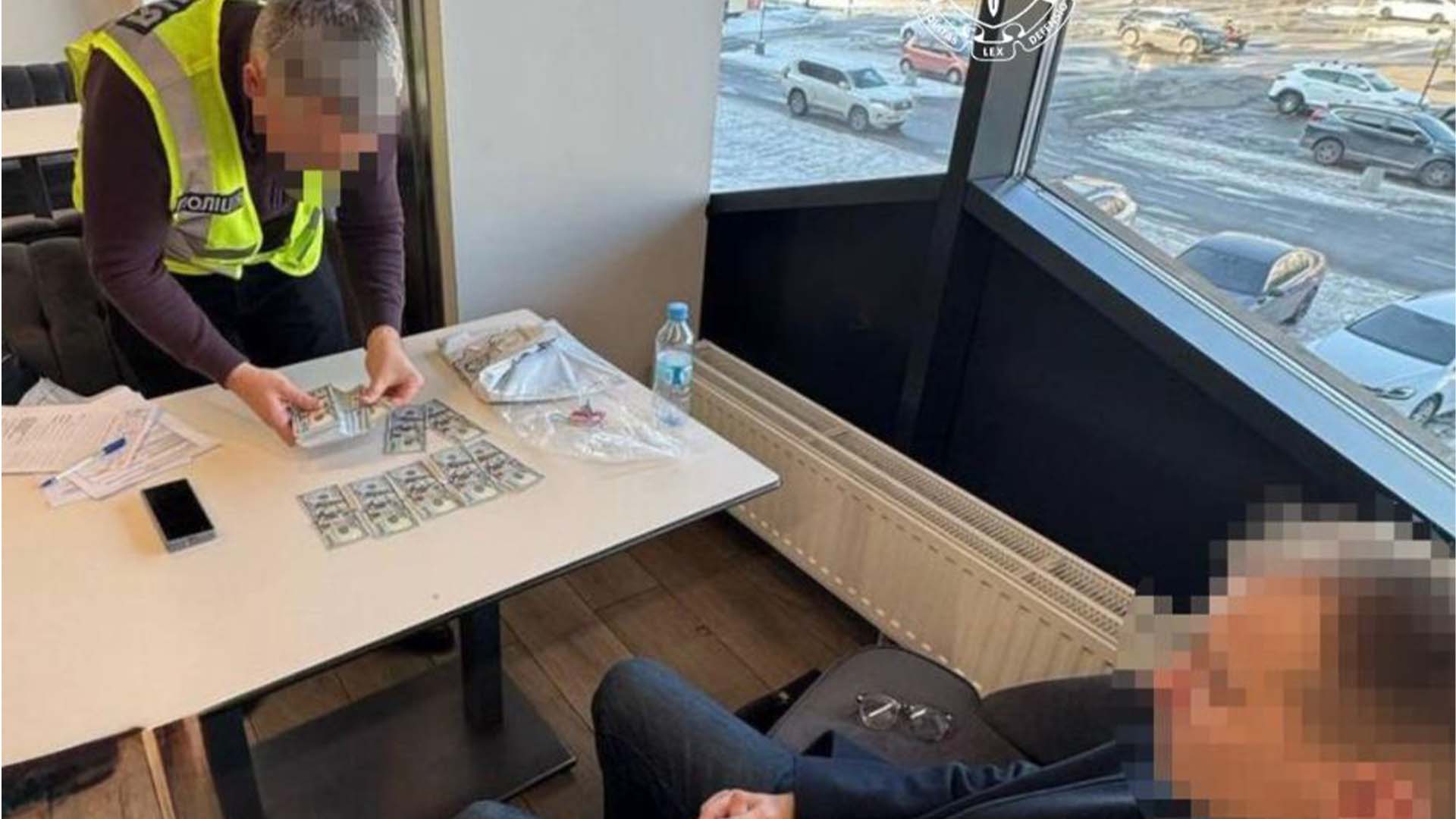 Підозрюваний і поліцейський, який рахує вилучені долари