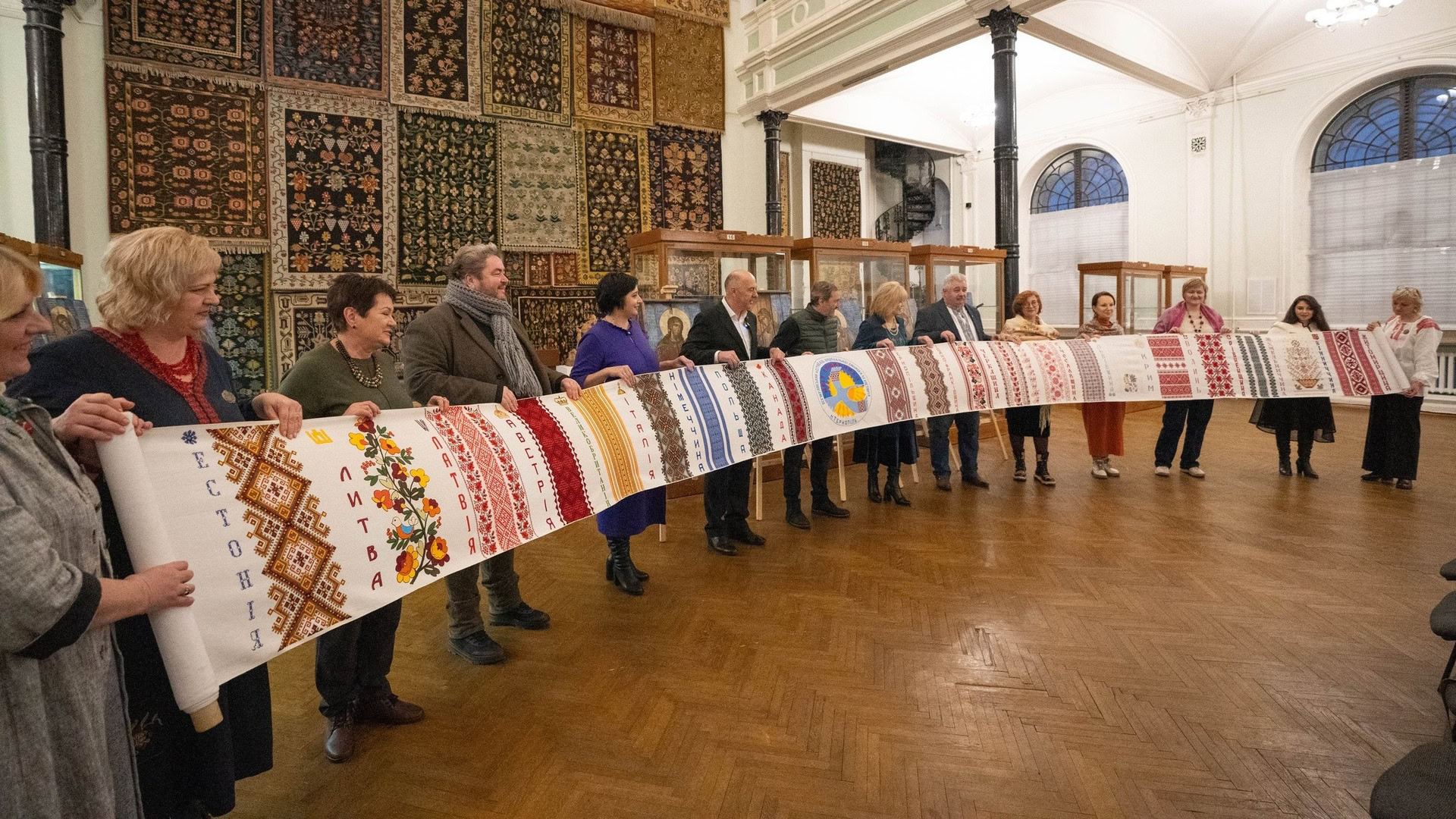 Люди тримають довжелезний вишитий рушник