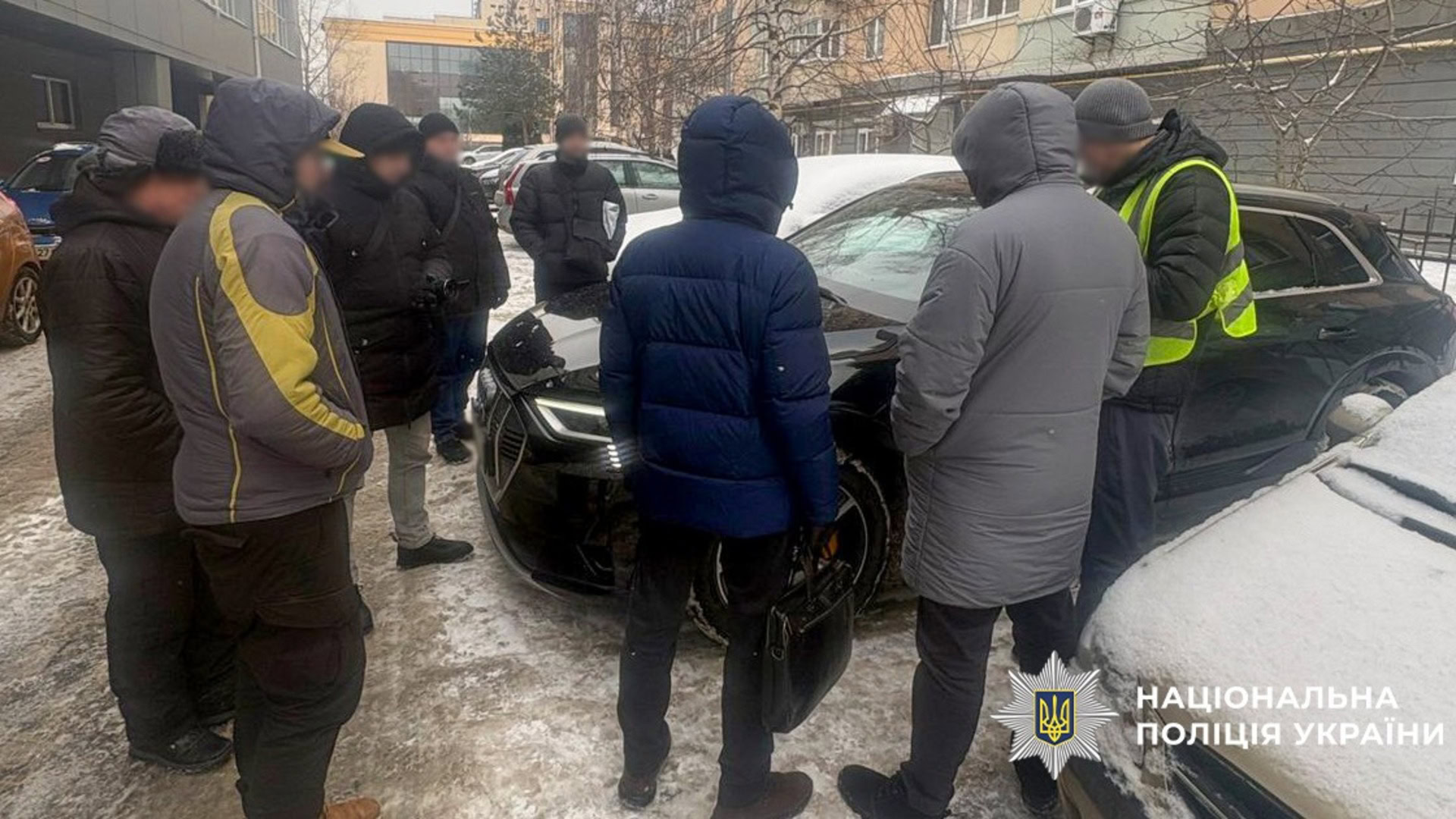 Правоохоронці і підозрюваний на вулиці біля автомобіля