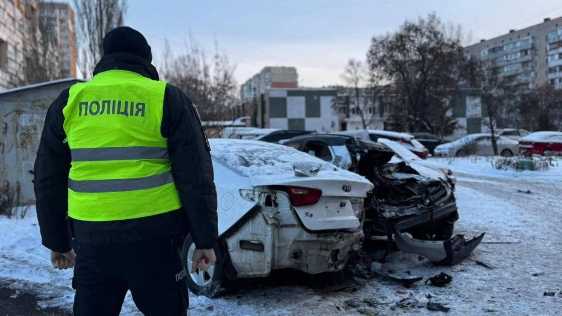 Поліцейський оглядає зруйновані автівки