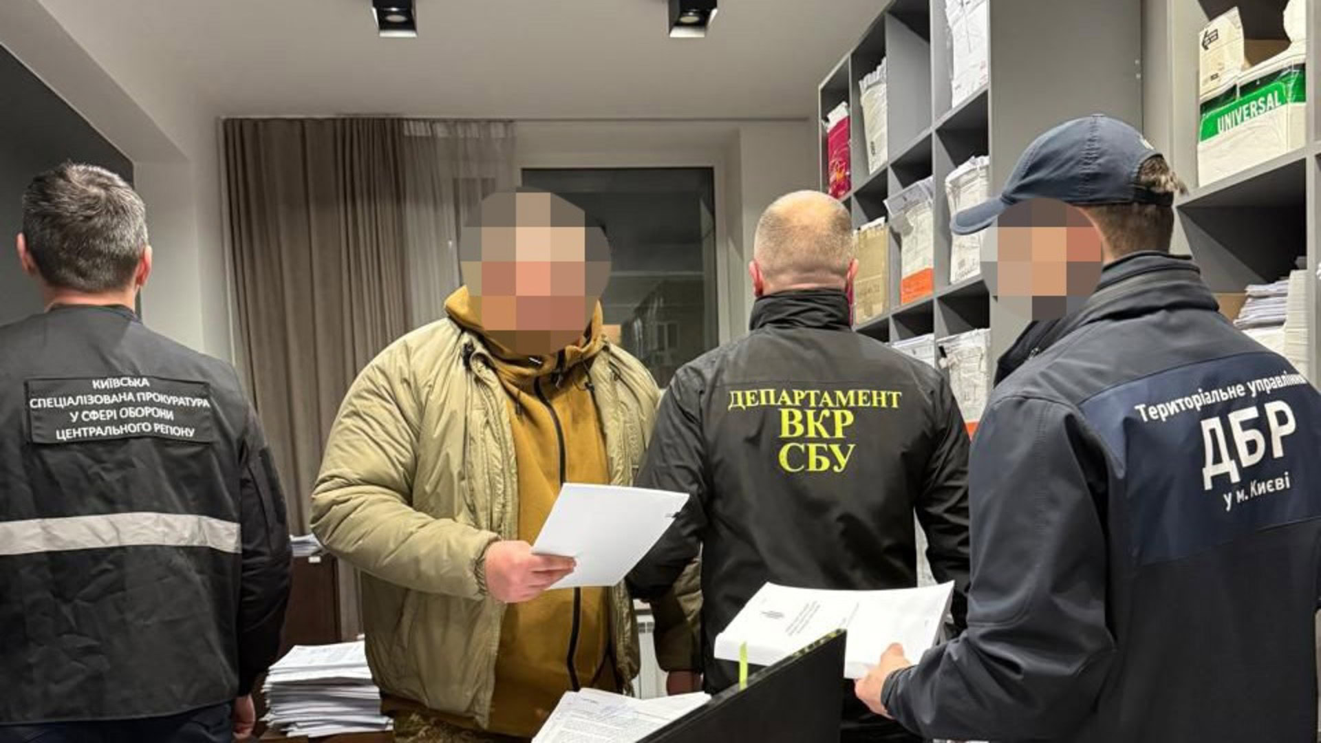 Правоохоронці і підозрюваний з документом у руці