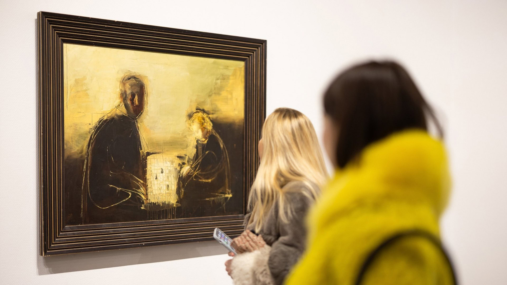 Відвідувачі на виставці розглядають картину