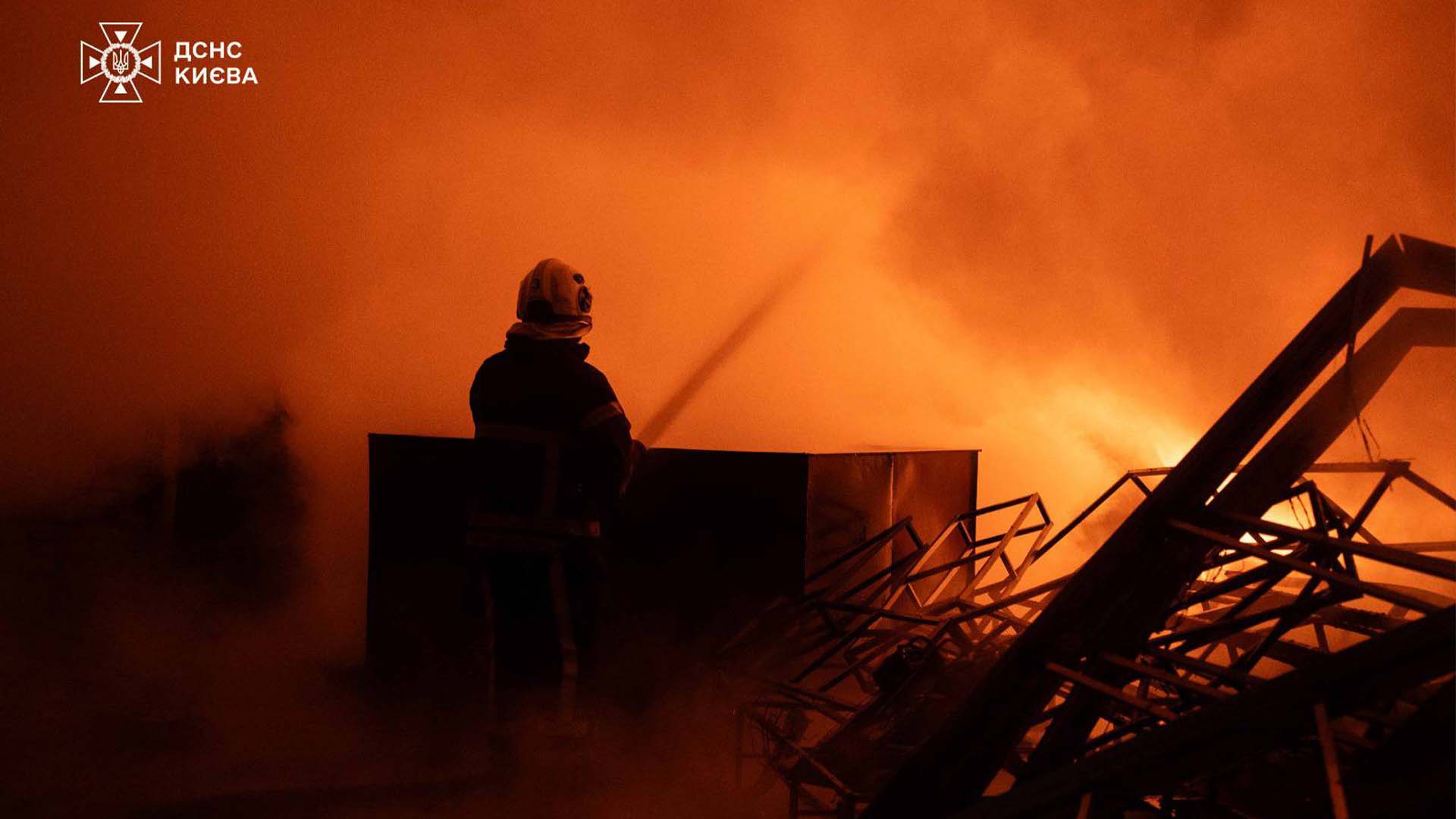 Пожежник гасить водою пожежу