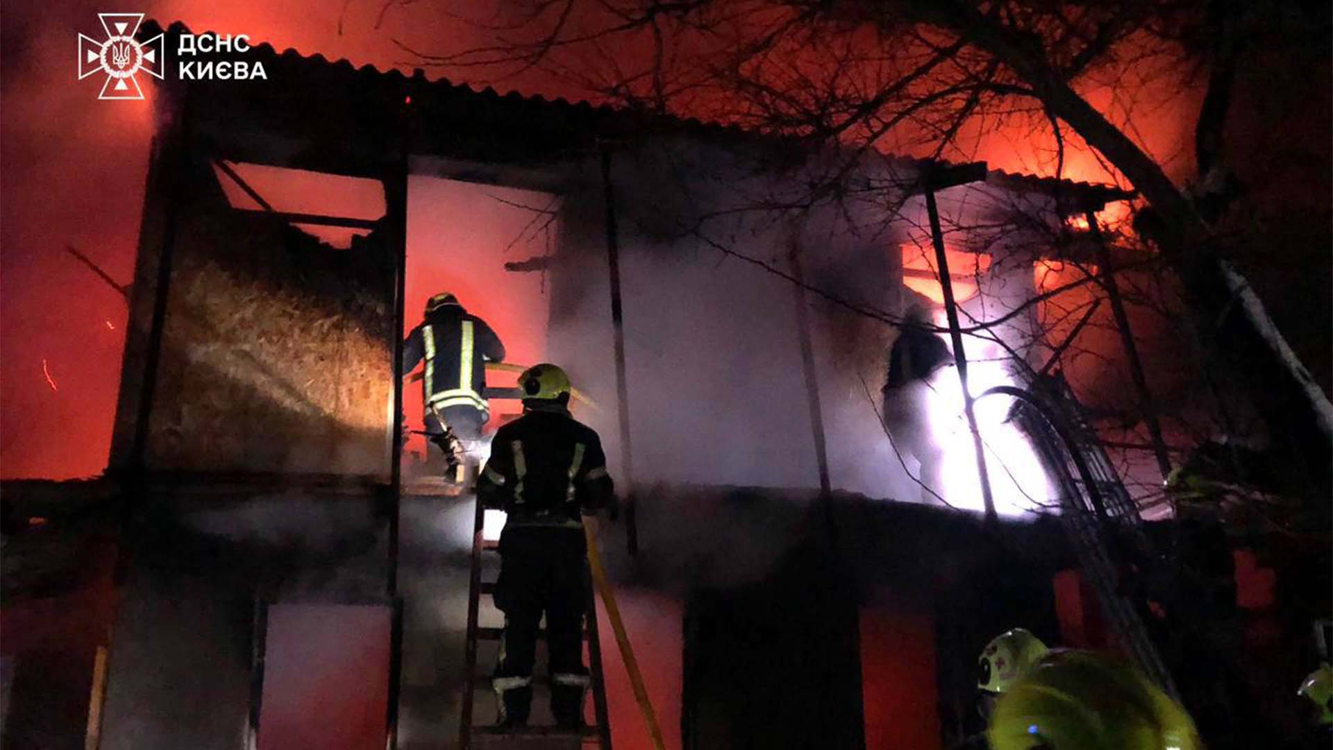 Пожежники по драбинах залазять в приміщення в якому вирує полум'я