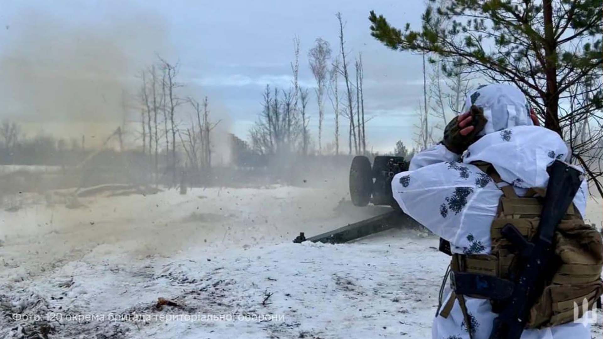 Військовий слідкує за пострілом артилерійської установки