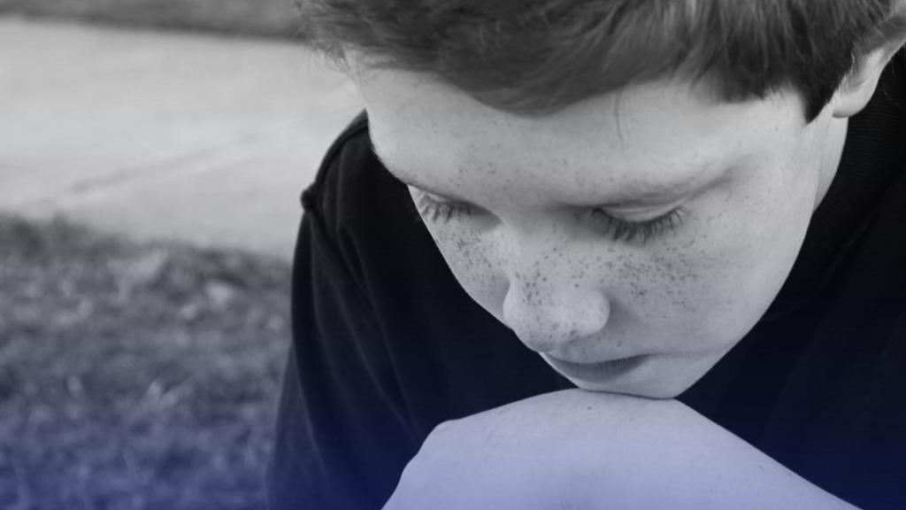 Засмучений хлопець, який поклав голову на руку