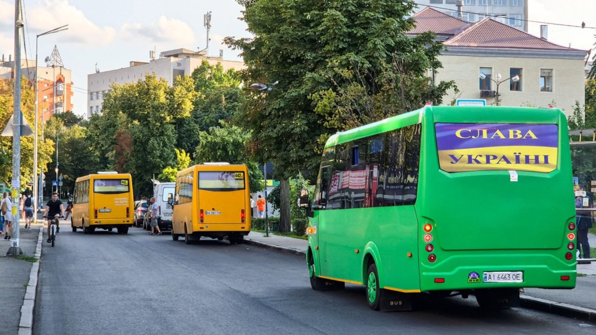 Автобуси маршрутів 442 та 442Д на вулиці Києва: зелений мікроавтобус із написом Слава Україні та жовті маршрутки