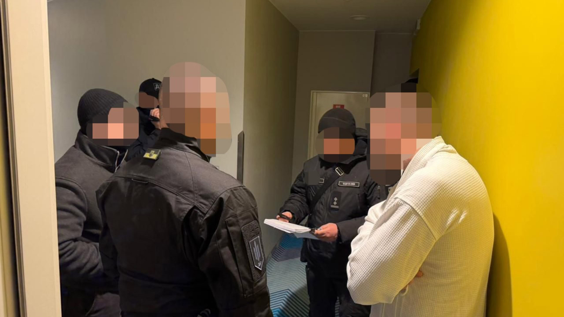 Працівники ДБР зачитують підозрюваному документ