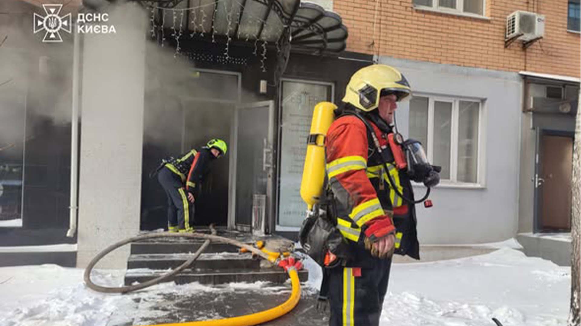 Двоє рятувальників ДСНС біля входу в салон краси на Печерську під час ліквідації пожежі генератора