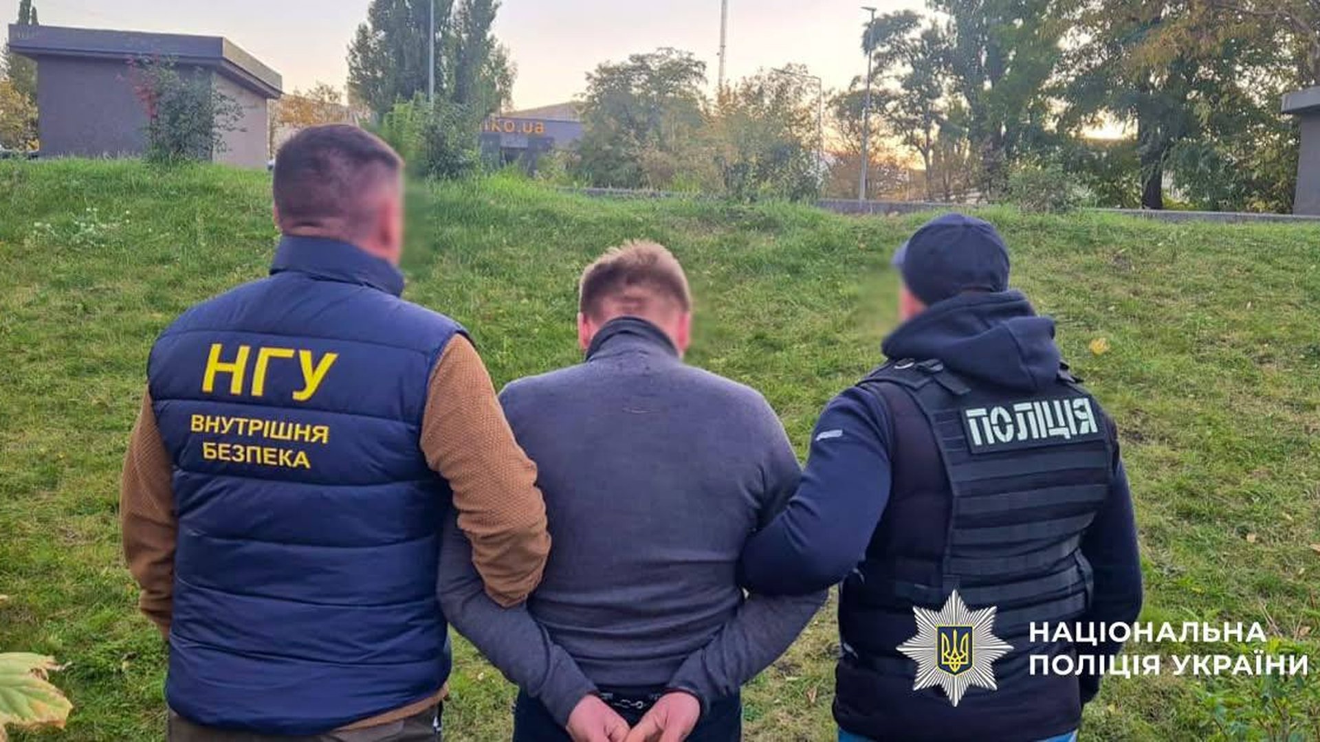 Співробітники НГУ та поліції ведуть затриманого підозрюваного у справі про незаконне бронювання від мобілізації у Києві