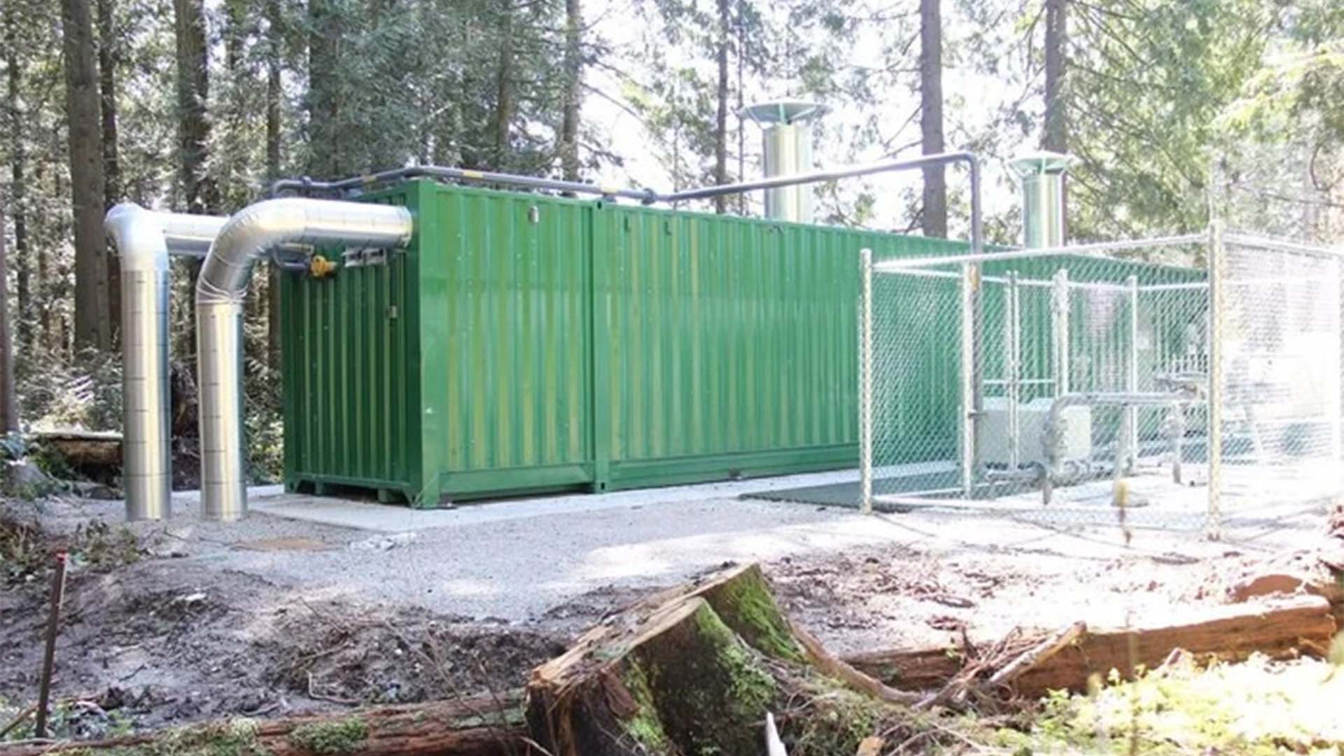 Зелений контейнер модульної котельні серед дерев у парку