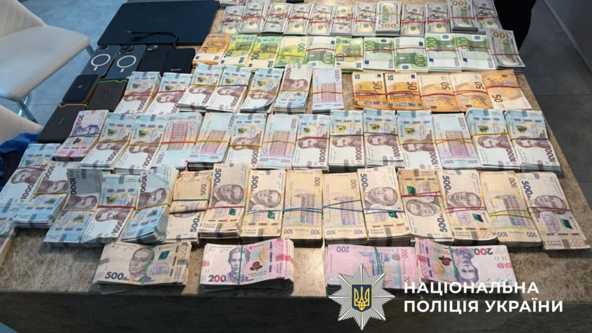Вилучені під час обшуків пачки готівки у гривнях, доларах та євро, мобільні телефони — речові докази у справі про розкрадання 50 млн грн на ремонті Трипільської ТЕС