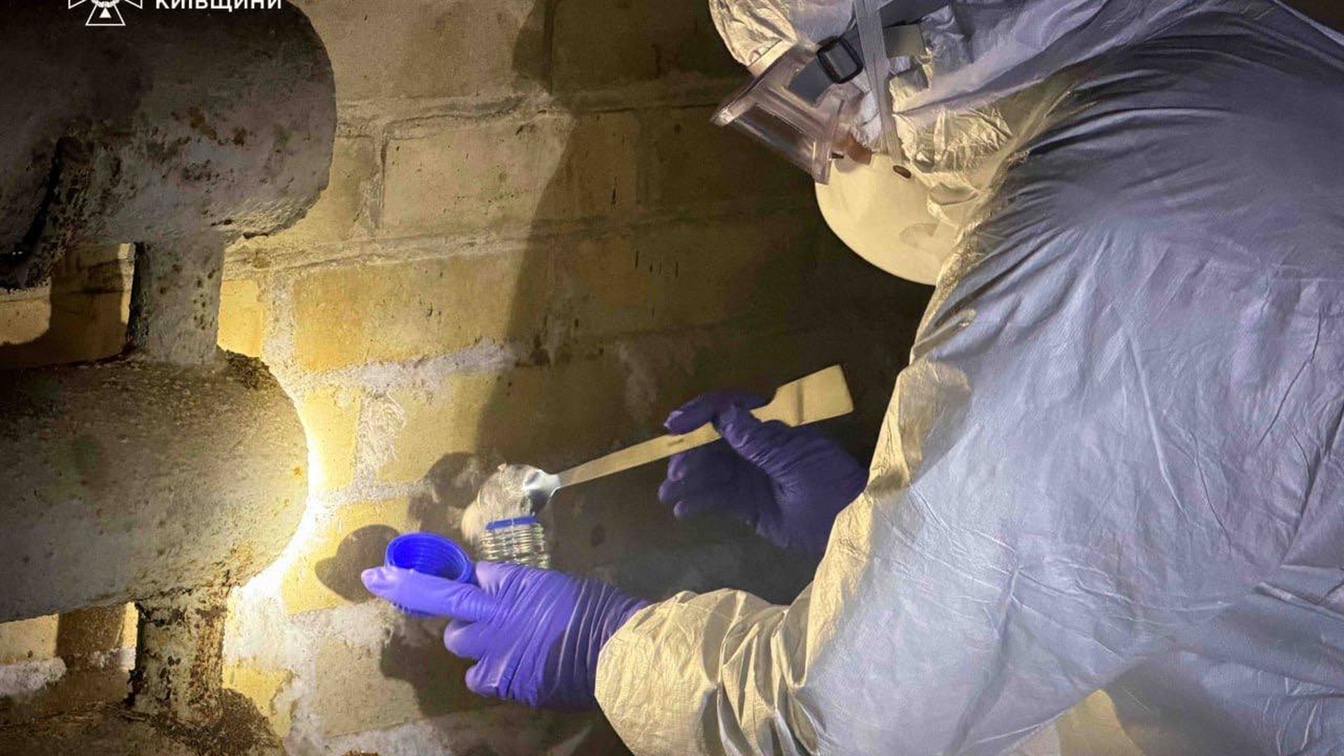 Фахівець ДСНС у захисному костюмі та рукавичках проводить експрес-аналіз невідомої сипучої речовини на підприємстві у Білій Церкві