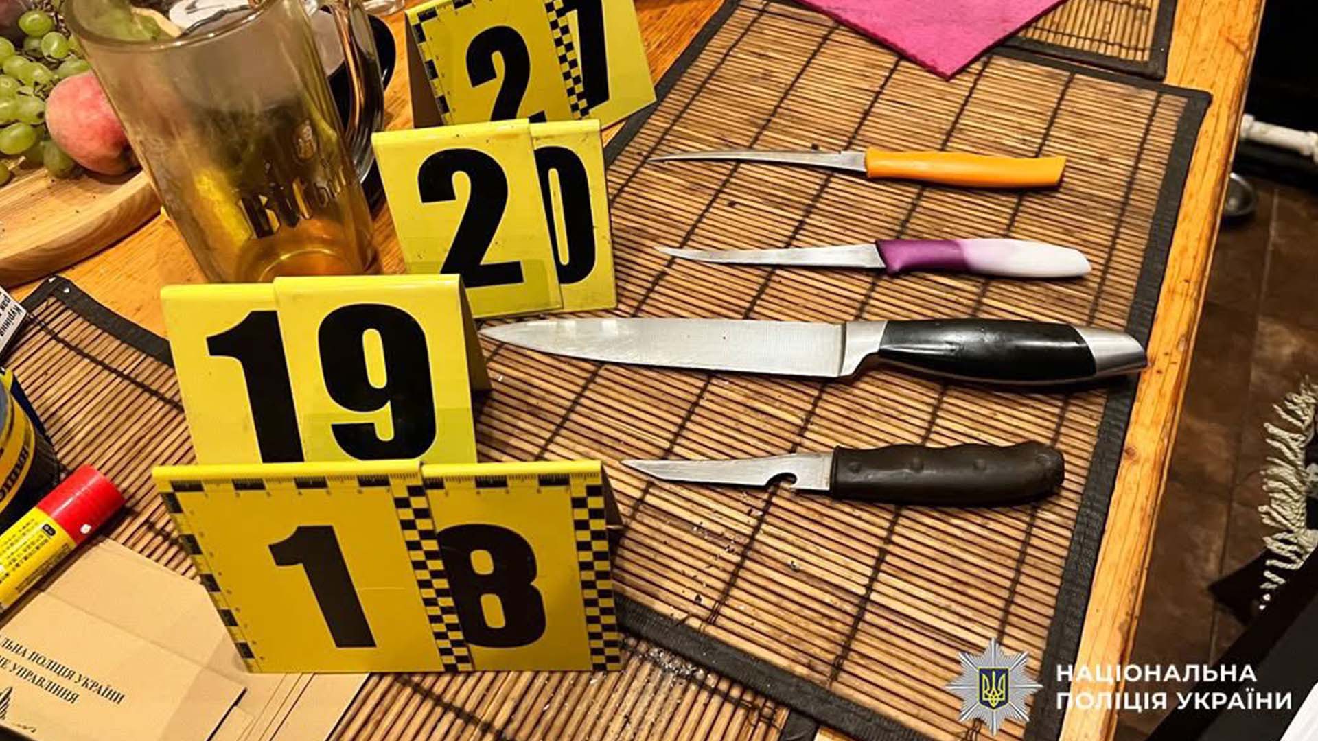 Кухонні ножі з жовтими маркерами речових доказів на столі поряд зі склянками під час огляду місця побутового злочину