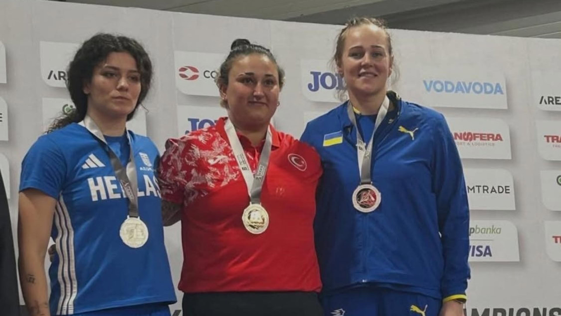Три спортсменки-призерки зі штовхання ядра на подіумі Балканського чемпіонату з легкої атлетики в Белграді, українка Ольга Голодна праворуч із бронзовою медаллю