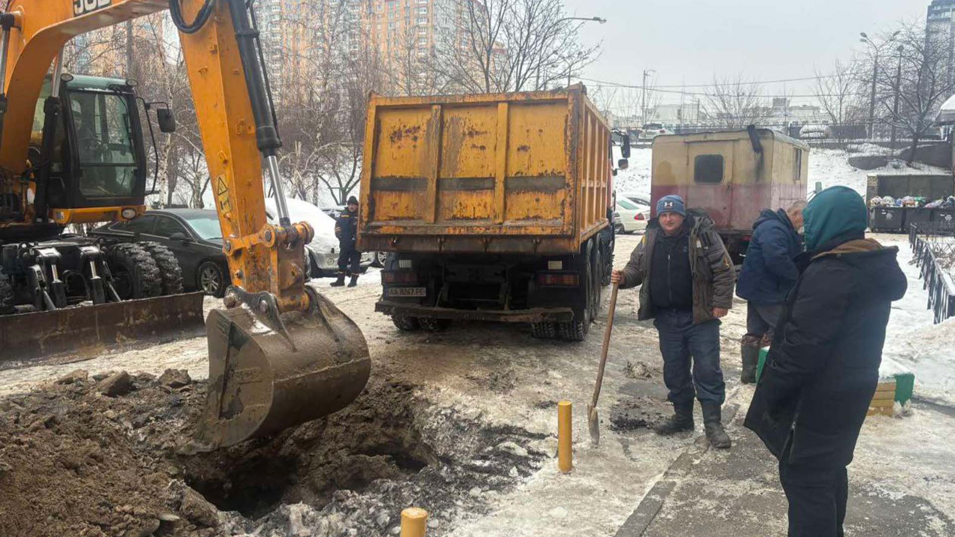 Працівники комунальних служб працюють поряд з екскаватором