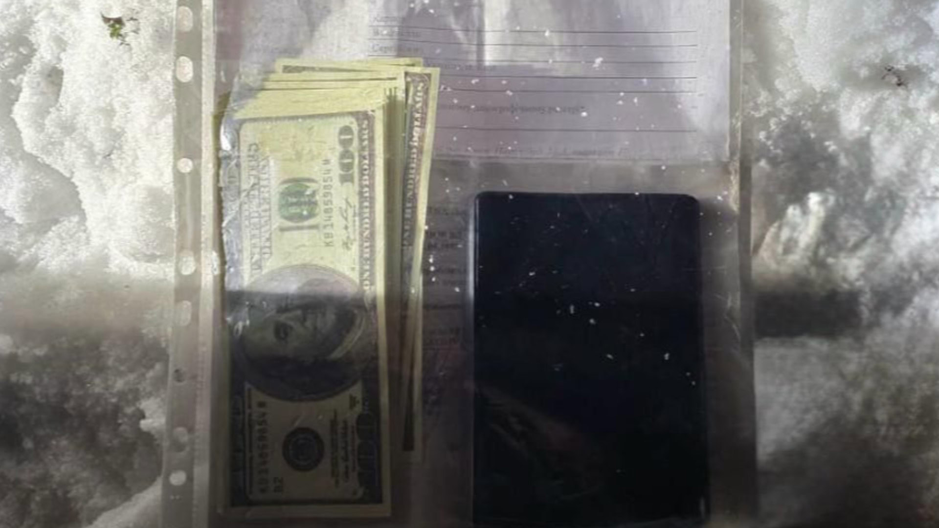 Вилучені долари та телефон під час затримання підозрюваного у схемі ухилення від мобілізації