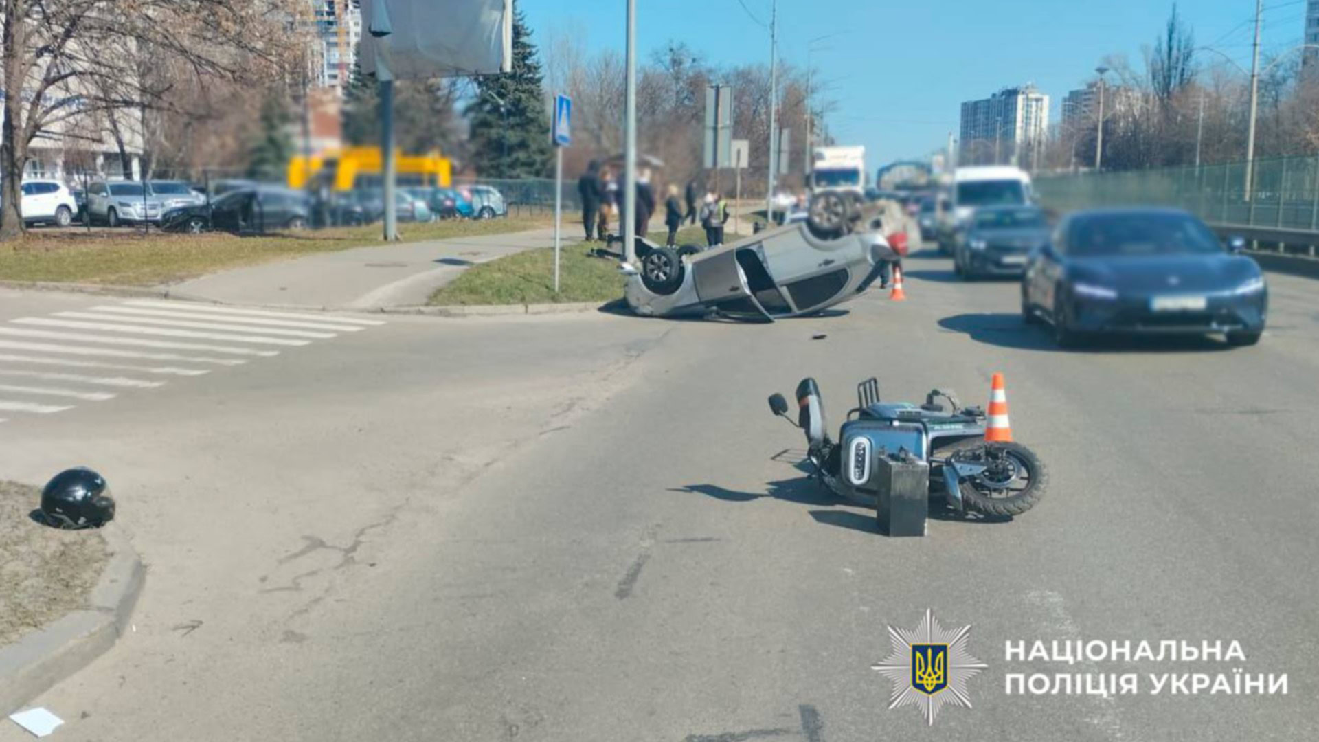 Перекинутий автомобіль Chevrolet та пошкоджений електроскутер на бульварі Леся Курбаса у Святошинському районі Києва після ДТП