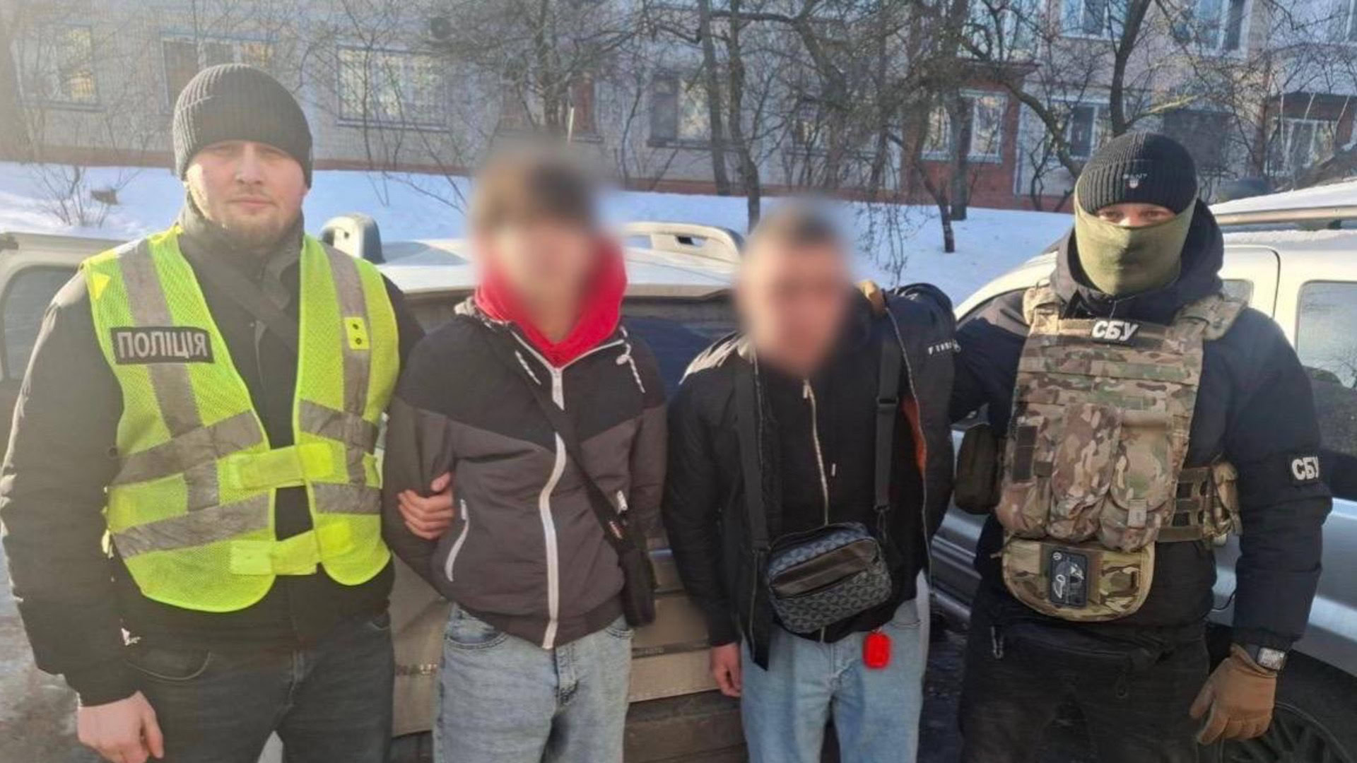 Поліцейський та працівник СБУ із затриманими підозрюваними у підпалах автомобілів військових у Києві