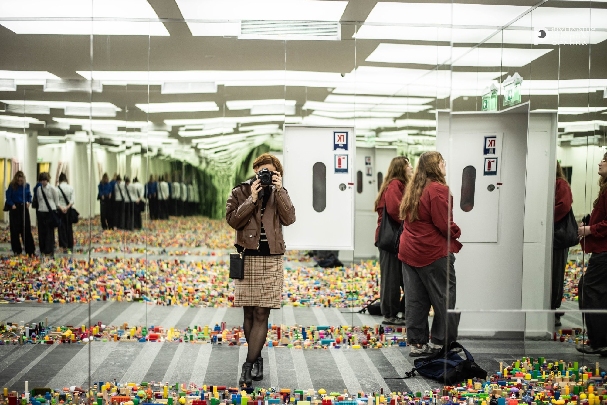Відвідувачка фотографує інсталяцію з LEGO у дзеркальному залі PinchukArtCentre на виставці Радість