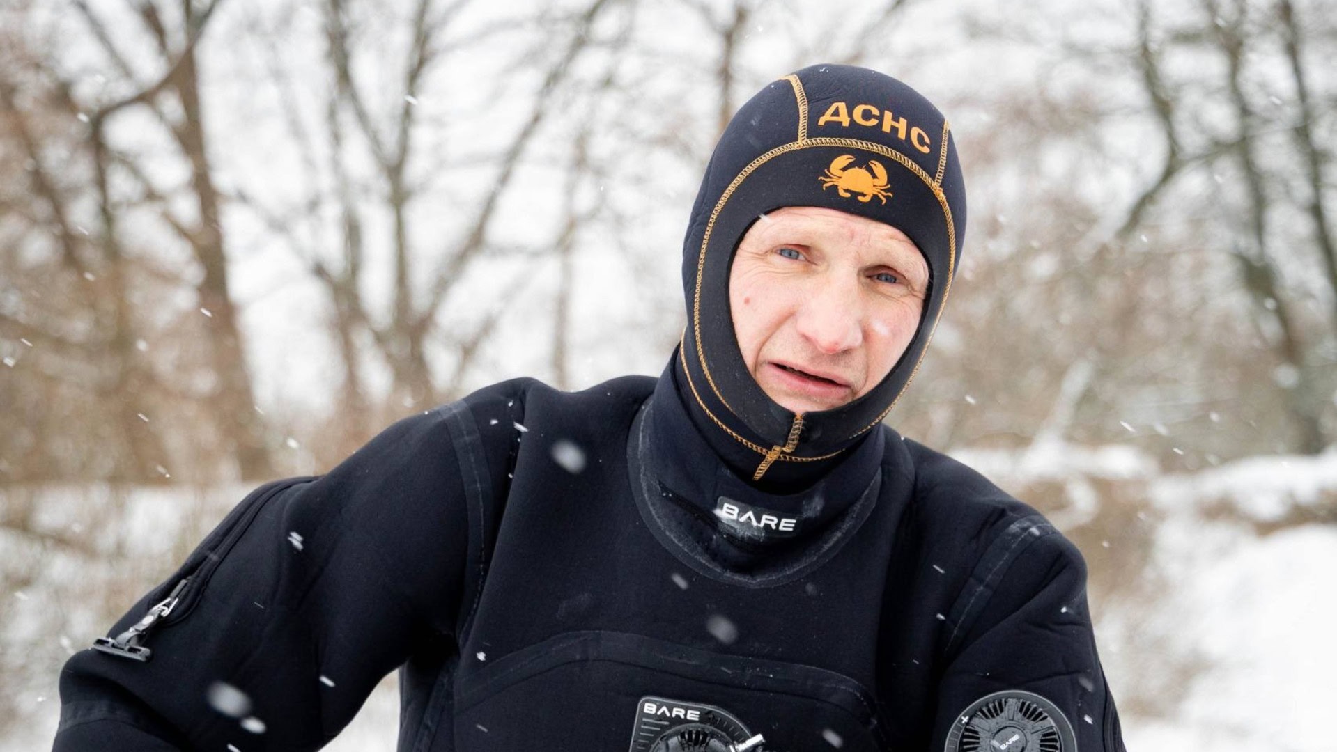 Водолаз ДСНС у чорному гідрокостюмі з написом «ДСНС» на шапці стоїть під снігом під час підводних робіт на ТЕЦ