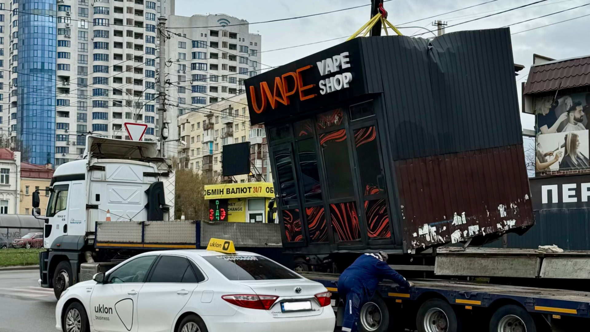 Кран піднімає незаконну тимчасову споруду вейп-шопу на Голосіївському проспекті у Києві для демонтажу