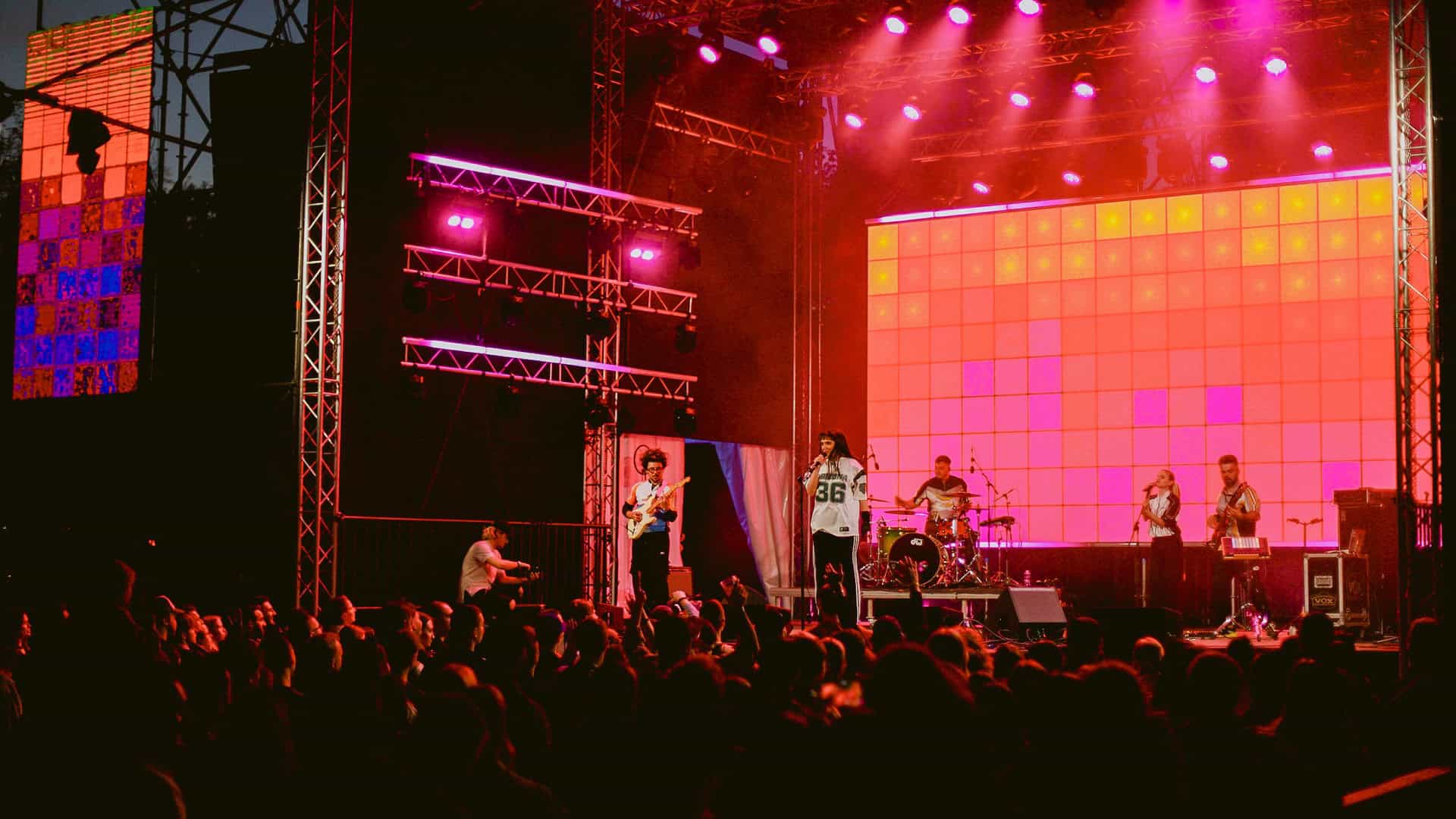 Виступ гурту на відкритій сцені фестивалю GARDEN BEER WEEKEND на ВДНГ у Києві — яскраве підсвічування, натовп глядачів та музиканти на сцені