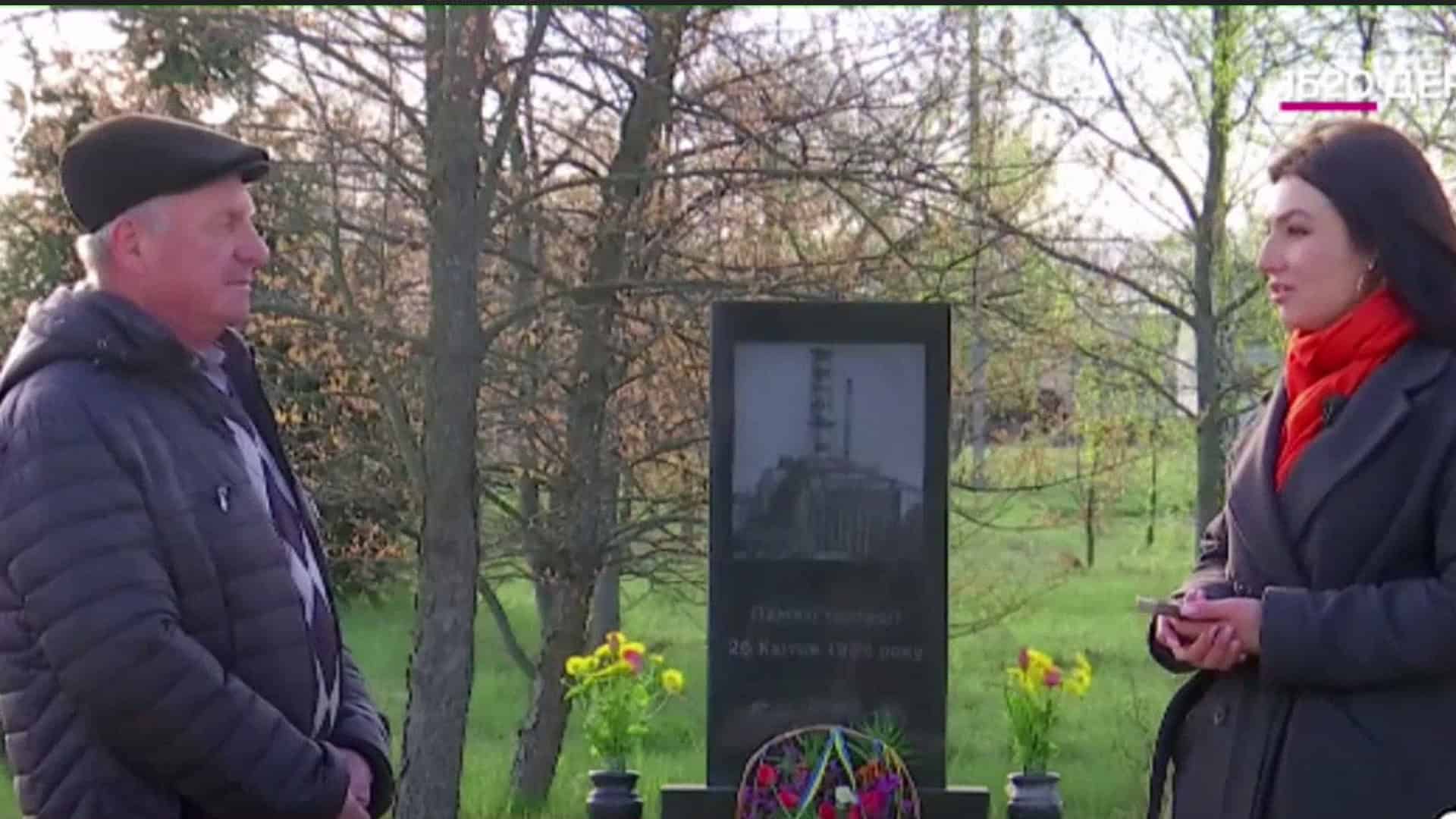 Ліквідатор аварії на ЧАЕС Олексій Заяць розмовляє з журналісткою біля меморіалу жертвам Чорнобильської трагедії — кадр із сюжету Kyiv24 до 40-річчя катастрофи