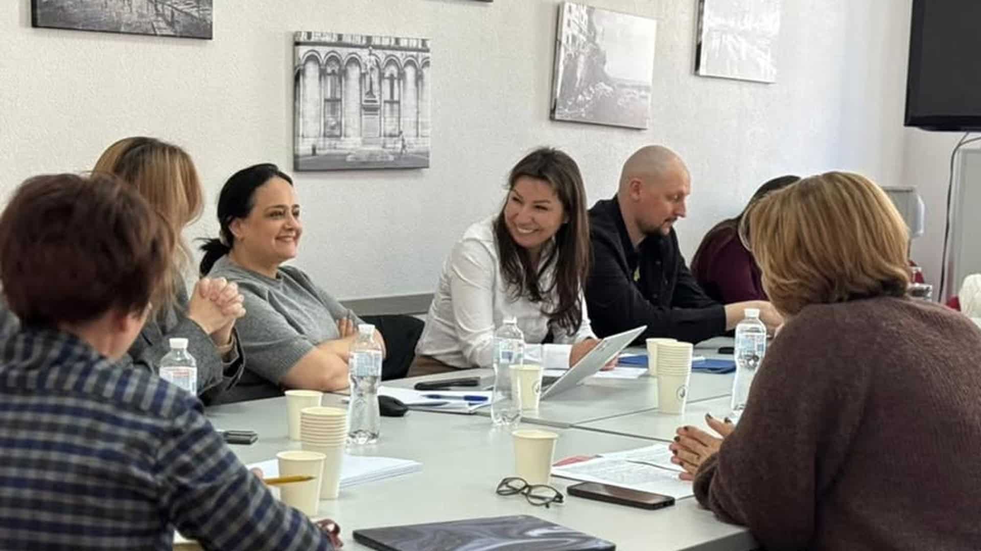 Учасники робочої зустрічі НСЗУ з директорами київських центрів первинної медико-санітарної допомоги сидять за столом переговорів у Департаменті охорони здоров'я КМДА