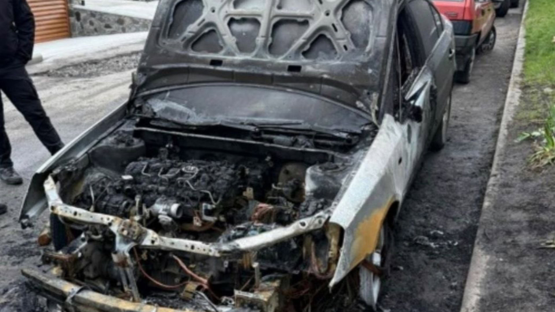 Згорілий автомобіль Kia Magentis із відкритим капотом та пошкодженим двигуном після умисного підпалу в Миронівці Київської області