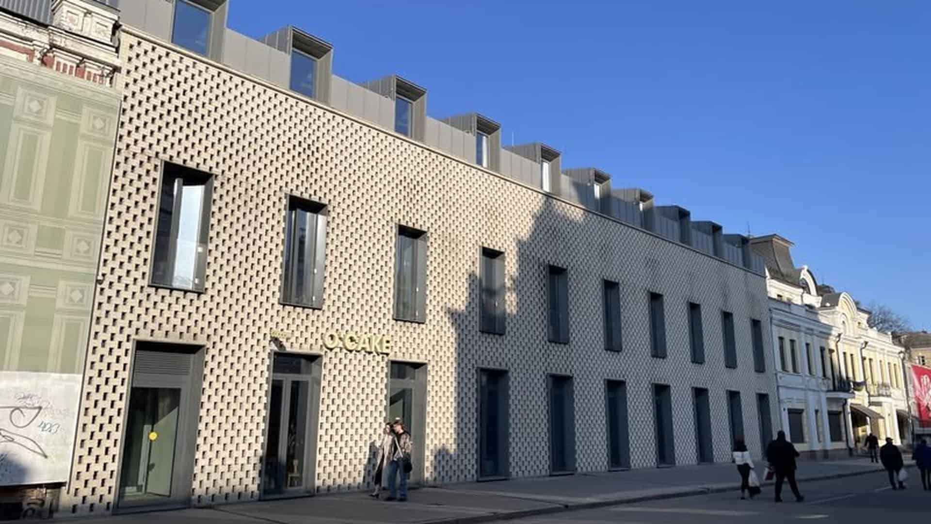 Сучасний фасад офісно-житлового комплексу Saga City Space на вулиці Петра Сагайдачного, 18, на Подолі в Києві — перфорована цегляна кладка на тлі блакитного неба