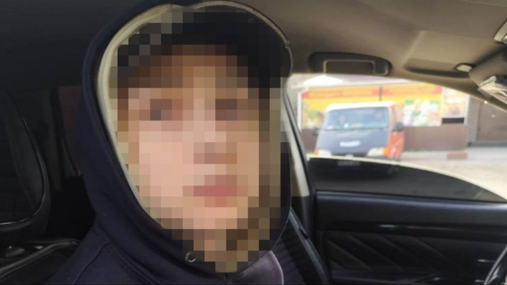 Затриманий виконавець теракту у Броварах сидить в автомобілі правоохоронців із замаскованим обличчям у темному капюшоні