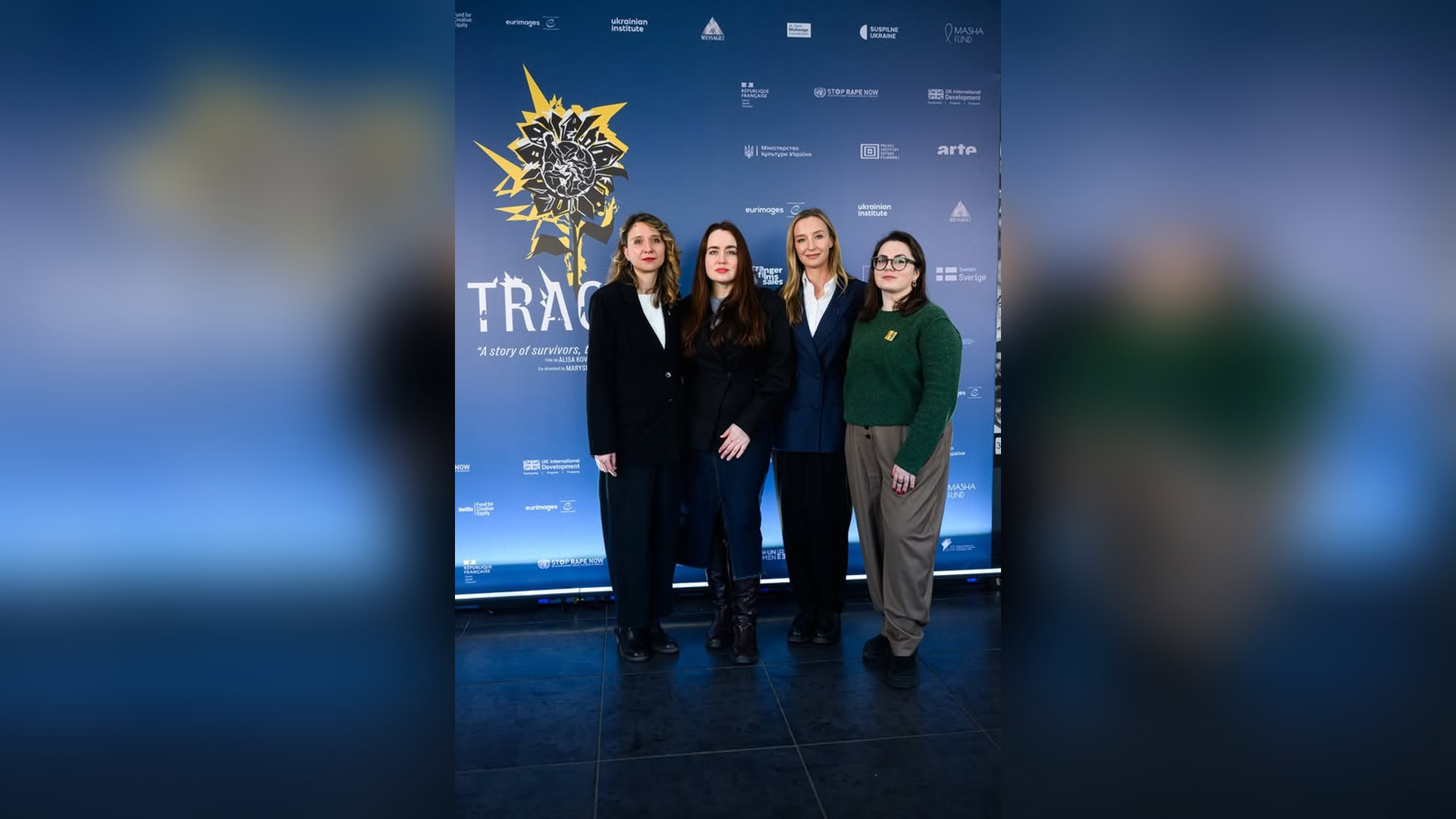Учасниці закритого показу документального фільму «Сліди» у Києві на фоні банера з назвою стрічки та логотипами партнерів