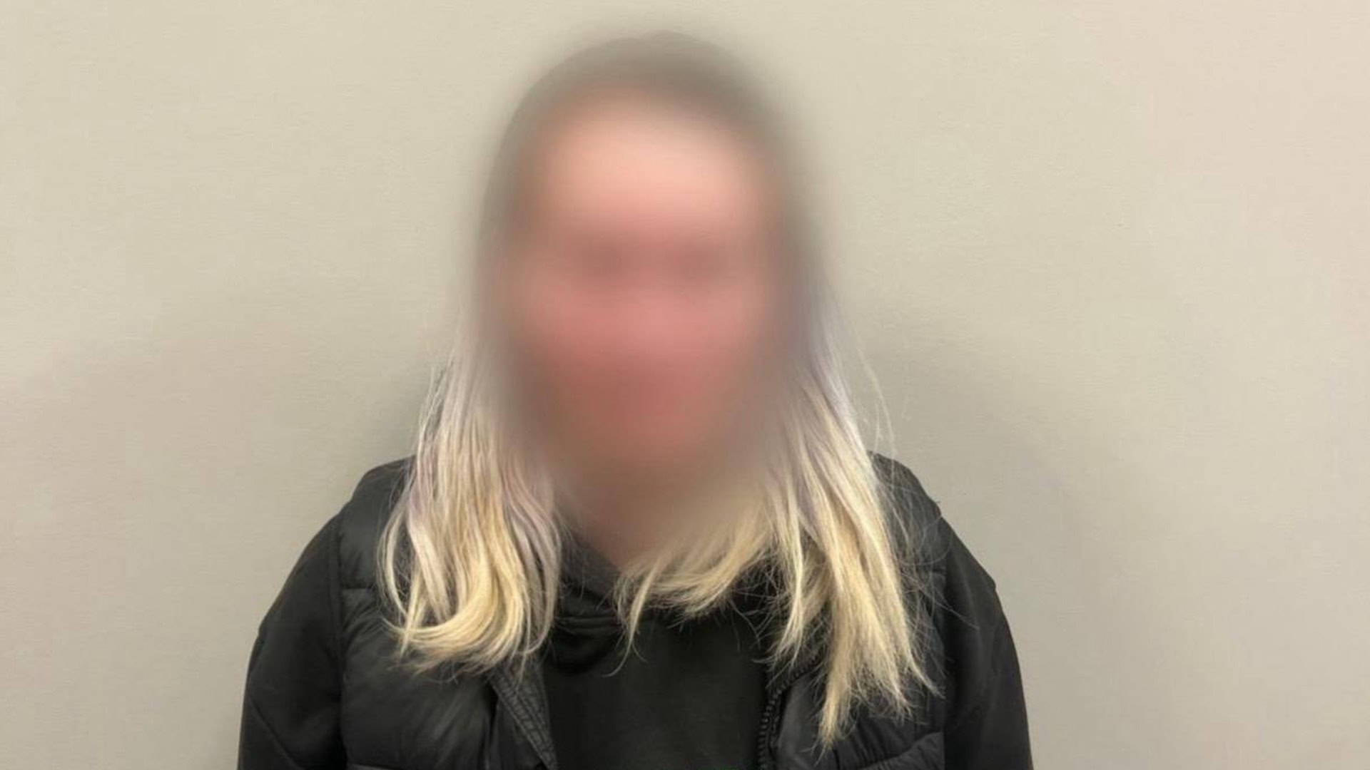 Затримана жінка з розмитим обличчям у чорній куртці, підозрювана у збуті метадону в Обухові