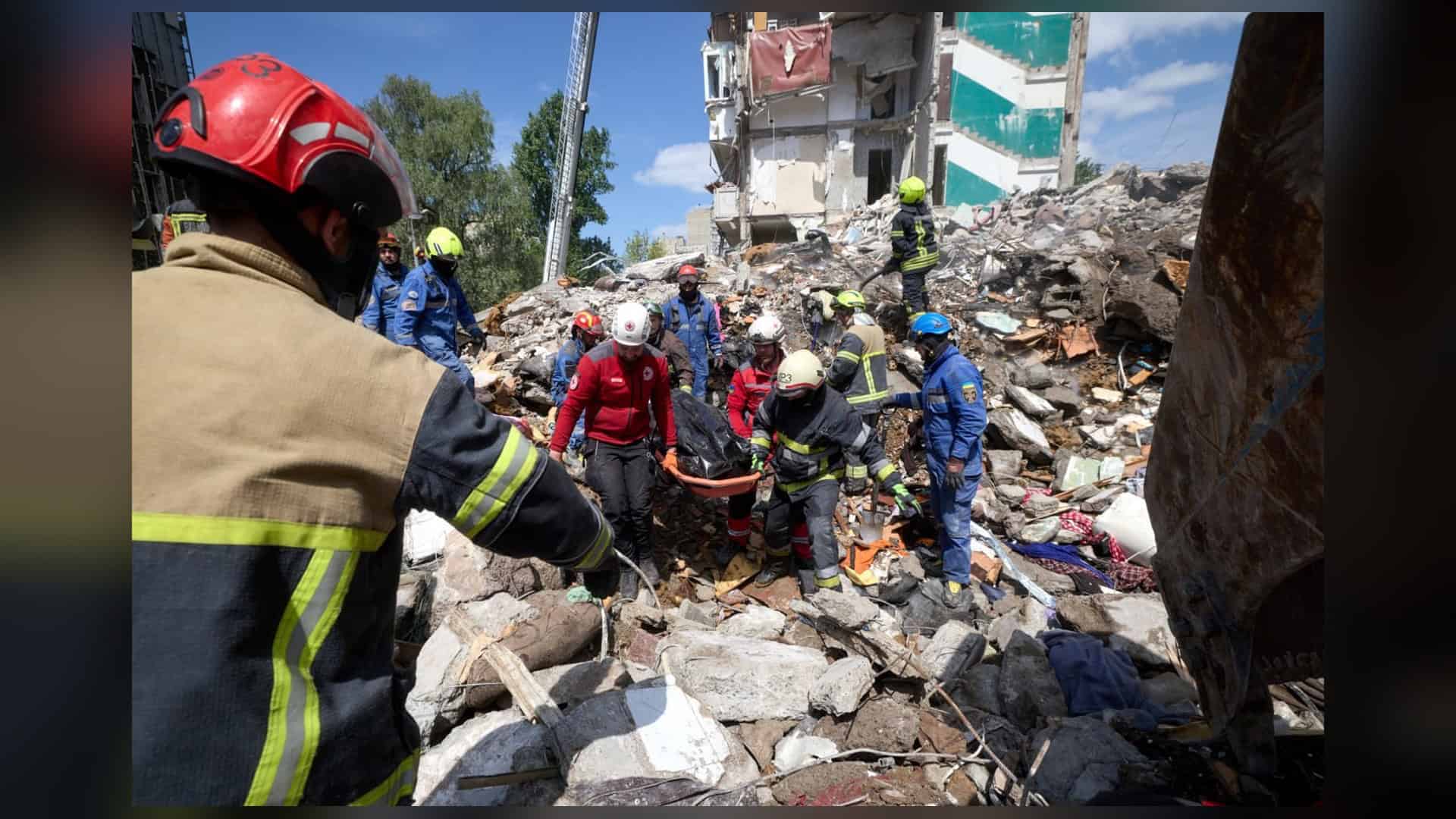 Рятувальники ДСНС, медики Червоного Хреста та волонтери дістають тіло загиблого із завалів зруйнованого житлового будинку в Дарницькому районі Києва після обстрілу 14 травня 2026