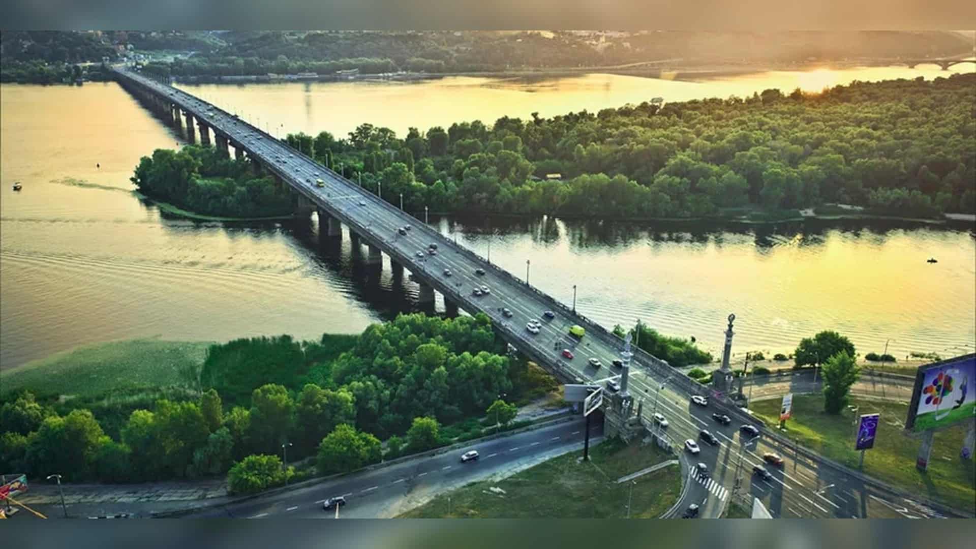 Аерофотозйомка мосту Патона через Дніпро у Києві на заході сонця, вид на обидва береги