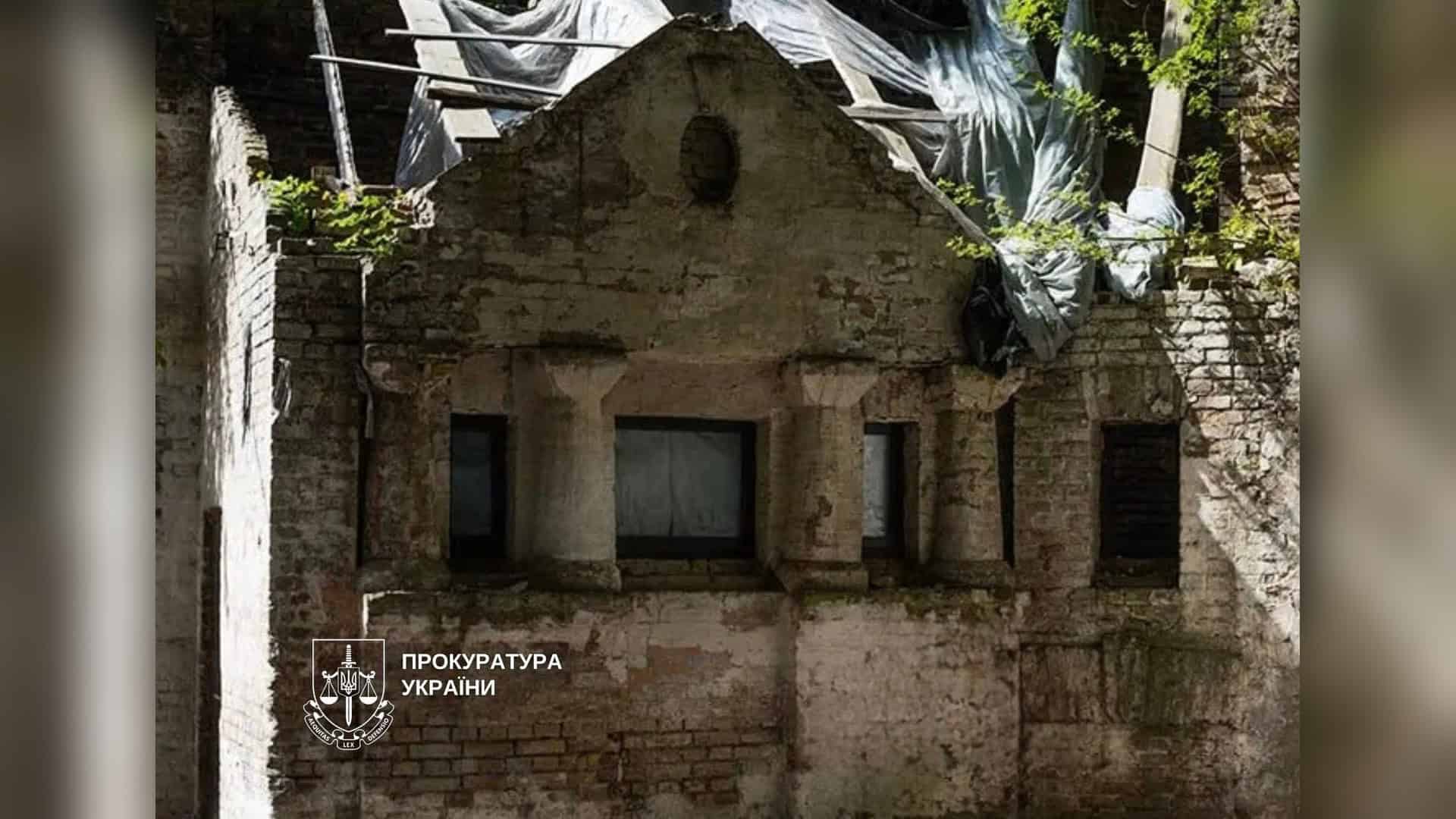 Занедбаний флігель садиби на вулиці Костельній у Києві з пошкодженим фасадом і накритим плівкою дахом