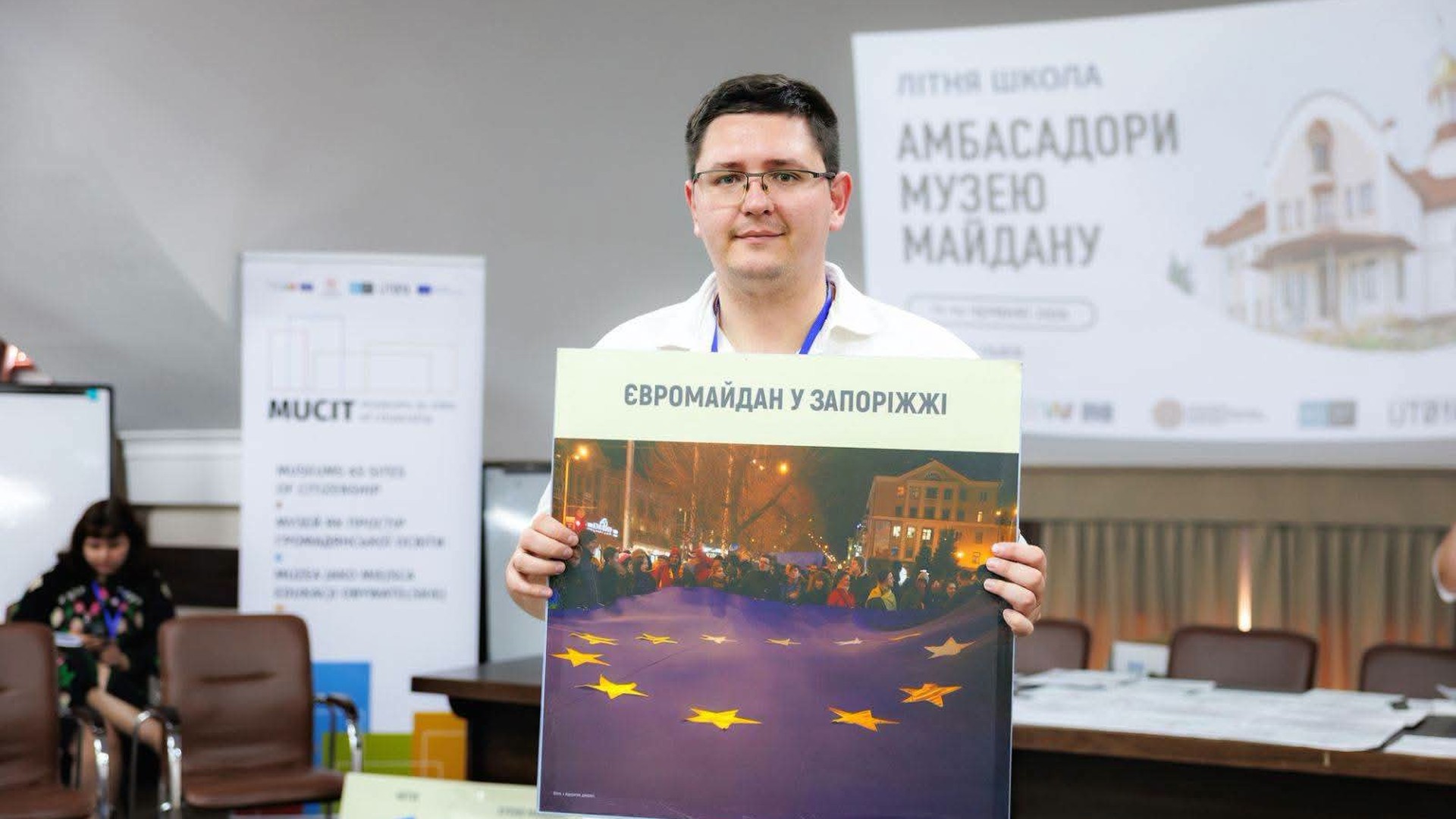 Вчитель історії Едуард Харченко тримає постер «Євромайдан у Запоріжжі» на Літній школі «Амбасадори Музею Майдану» у Львові